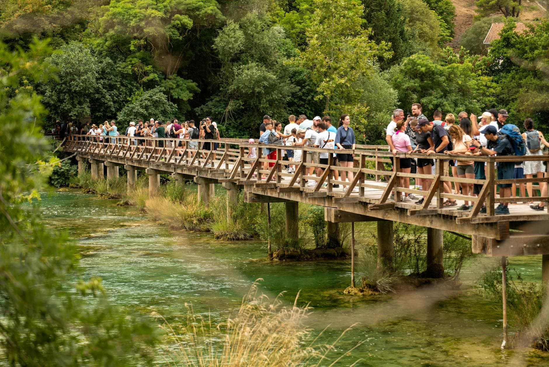 Visitors enjoy scenery from a wooden bridge in Krka National Park, Croatia.