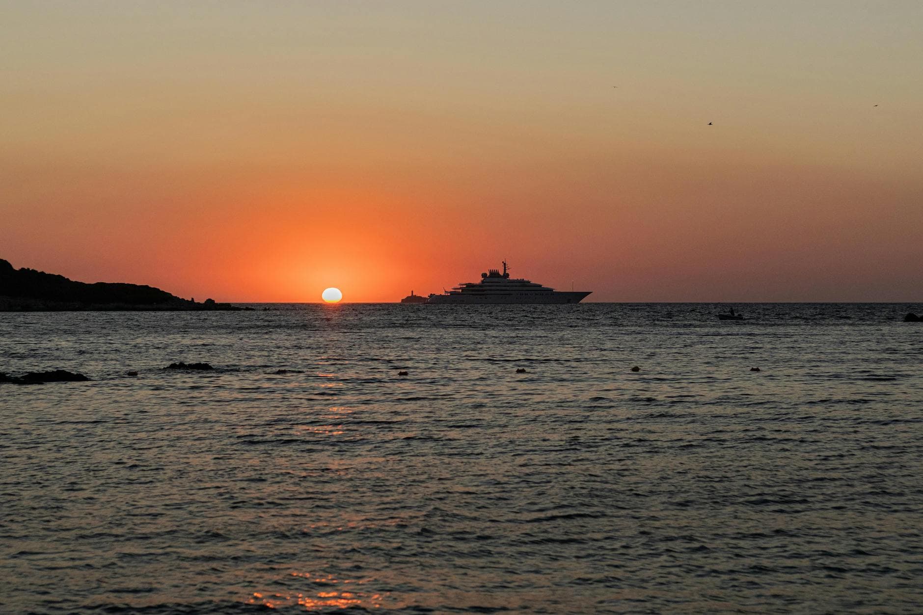 Serenity at sunset with a yacht silhouette in Ksamil, Albania's scenic coastal view.