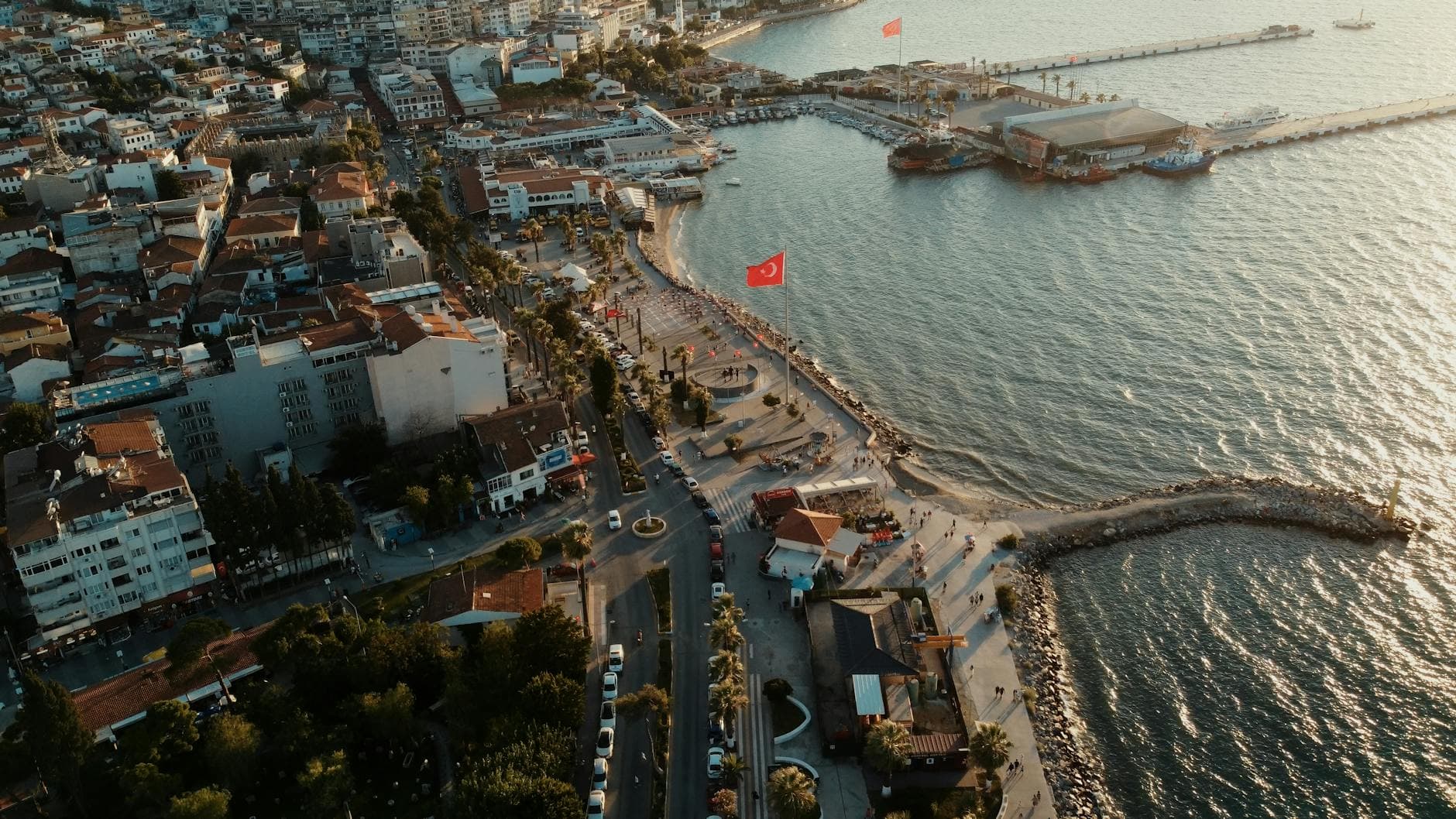 Captivating aerial shot of Kuşadası harbor, showcasing the waterfront and cityscape at sunset.