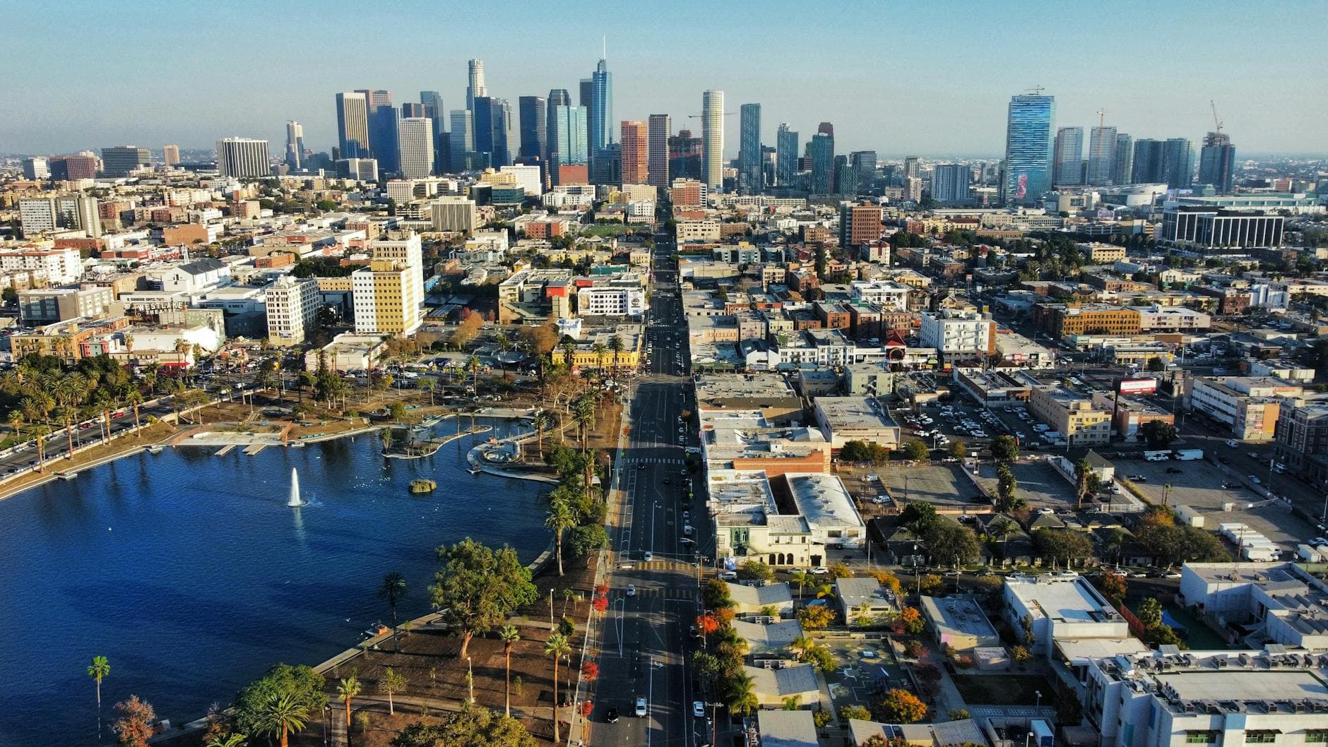 Stunning aerial shot of downtown Los Angeles with skyscrapers, city streets, and a serene park.