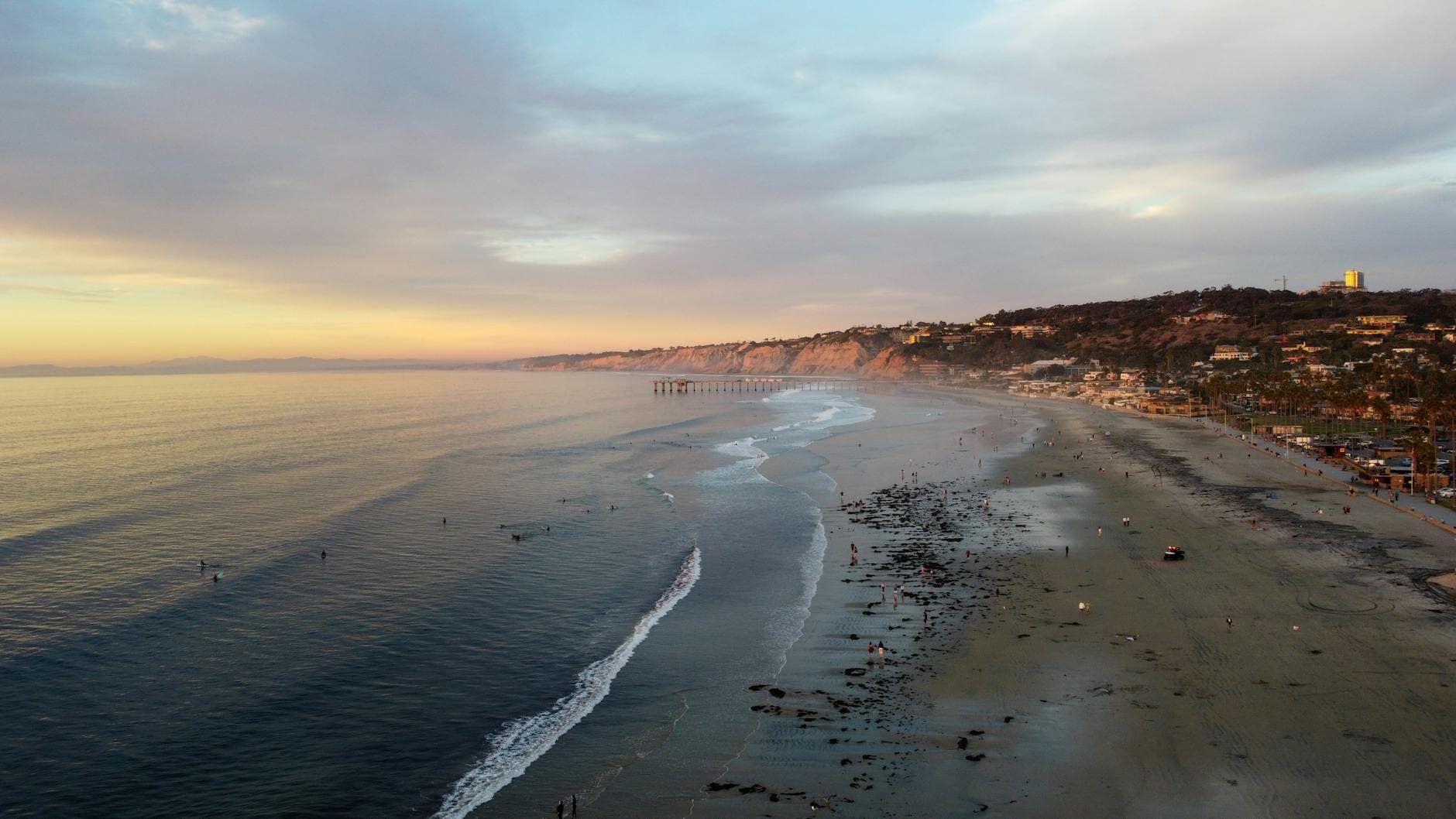 Stunning aerial view of San Diego beach with gentle waves at sunset.