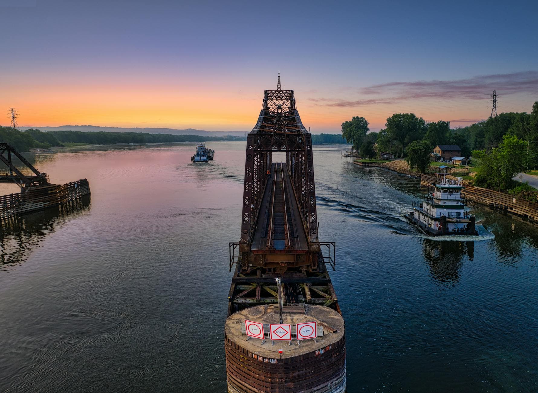 Aerial view of the Mississippi River and La Crescent Railroad Bridge in serene sunset light.