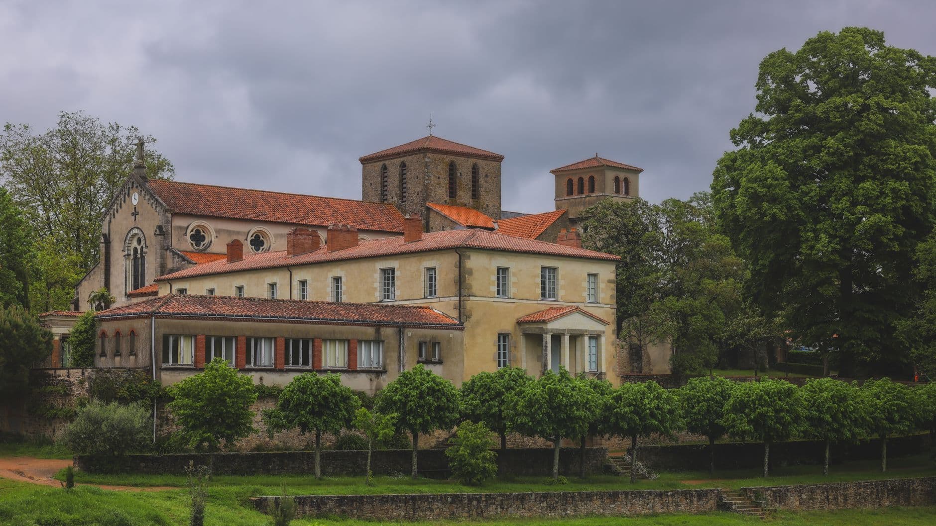 A stunning view of a historic church with lush greenery in Clisson, France.