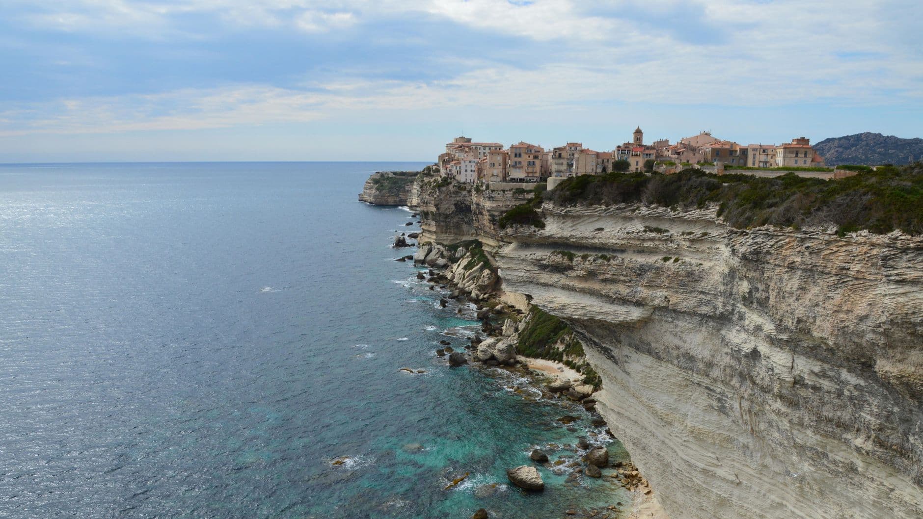 Dramatic cliffside view of Bonifacio, Corsica, showcasing stunning natural beauty and historic architecture.