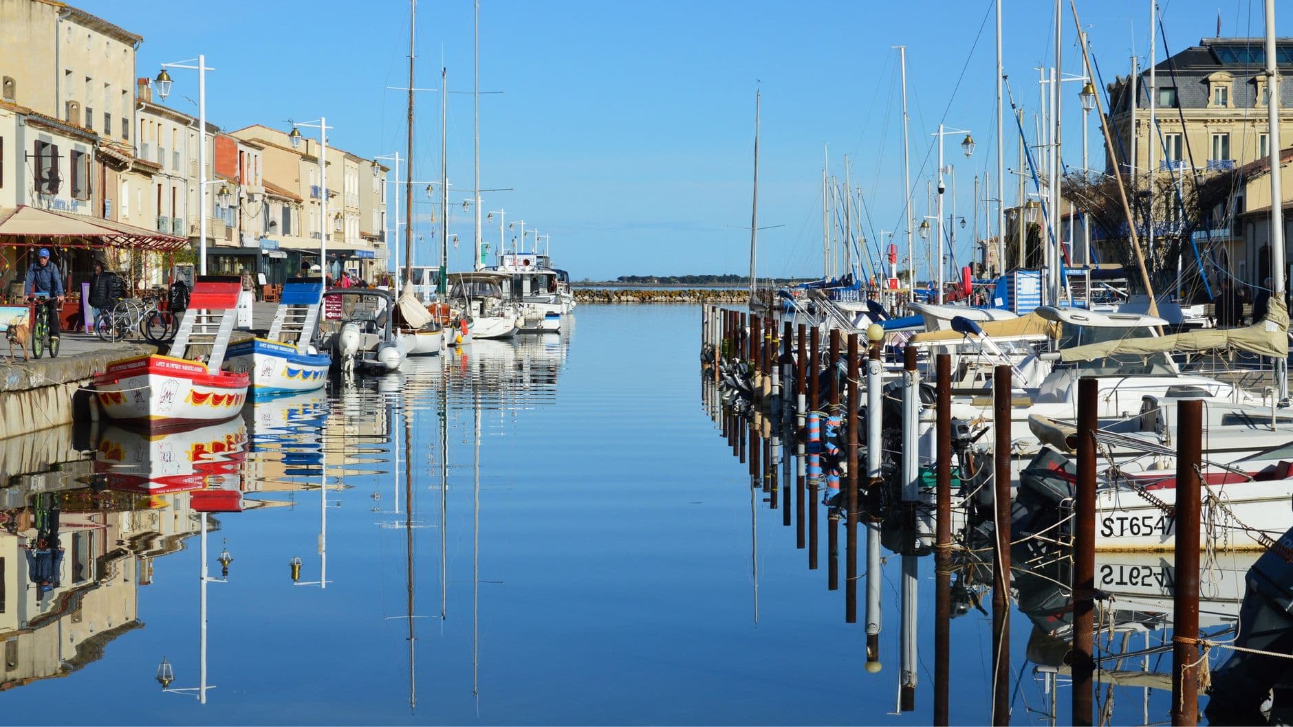 A vibrant view of the waterfront with boats in Marseillan, Occitanie, France.