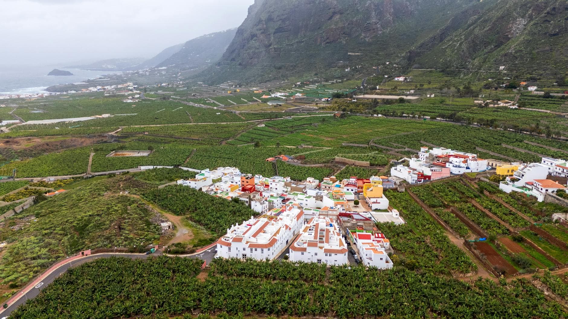 Scenic aerial view of Buenavista del Norte, lush farmland, and the dramatic coastline of Tenerife.