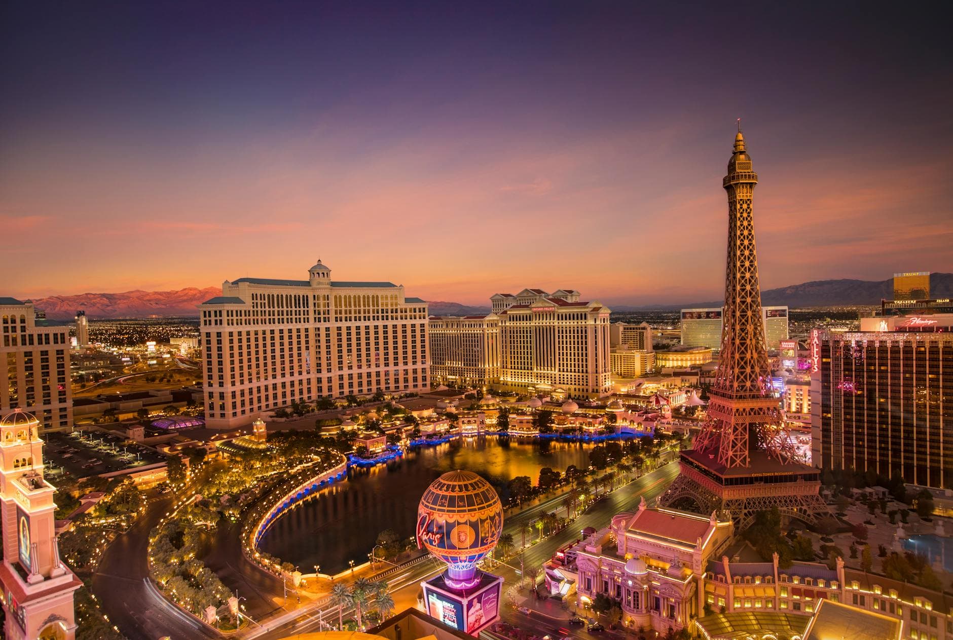 Stunning aerial view of Las Vegas Strip at sunset with iconic Eiffel Tower replica and vibrant cityscape.
