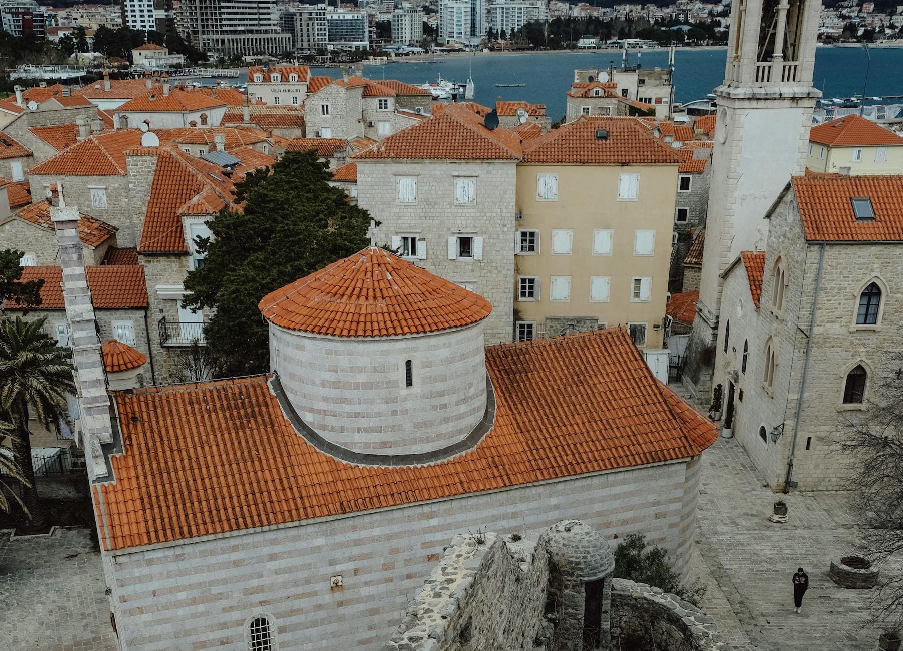 Aerial view of Budva's historic cityscape with Byzantine architecture and orange rooftops.