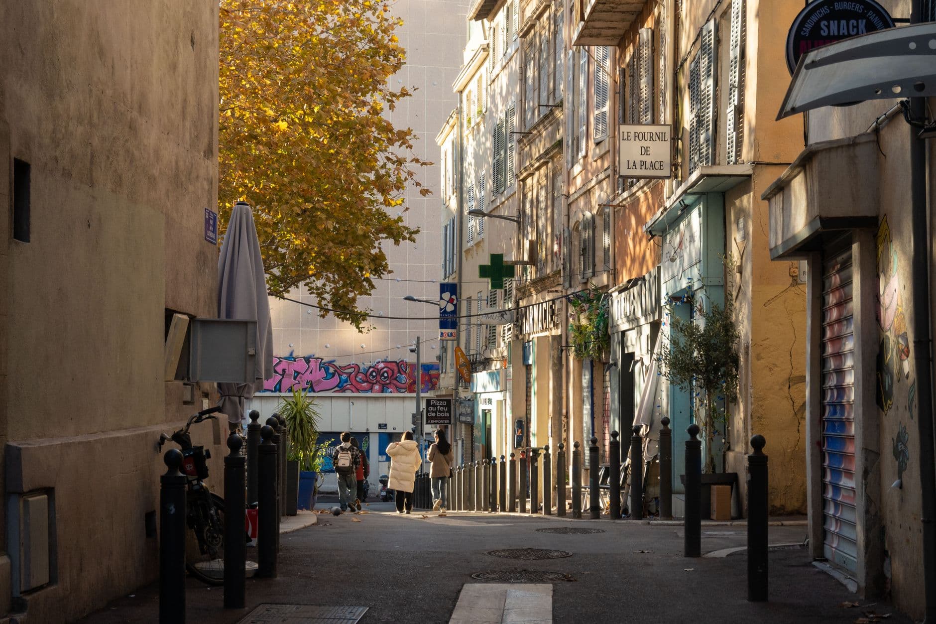 Idyllic street view with people walking in the warm glow of Marseille, capturing urban charm and local life.