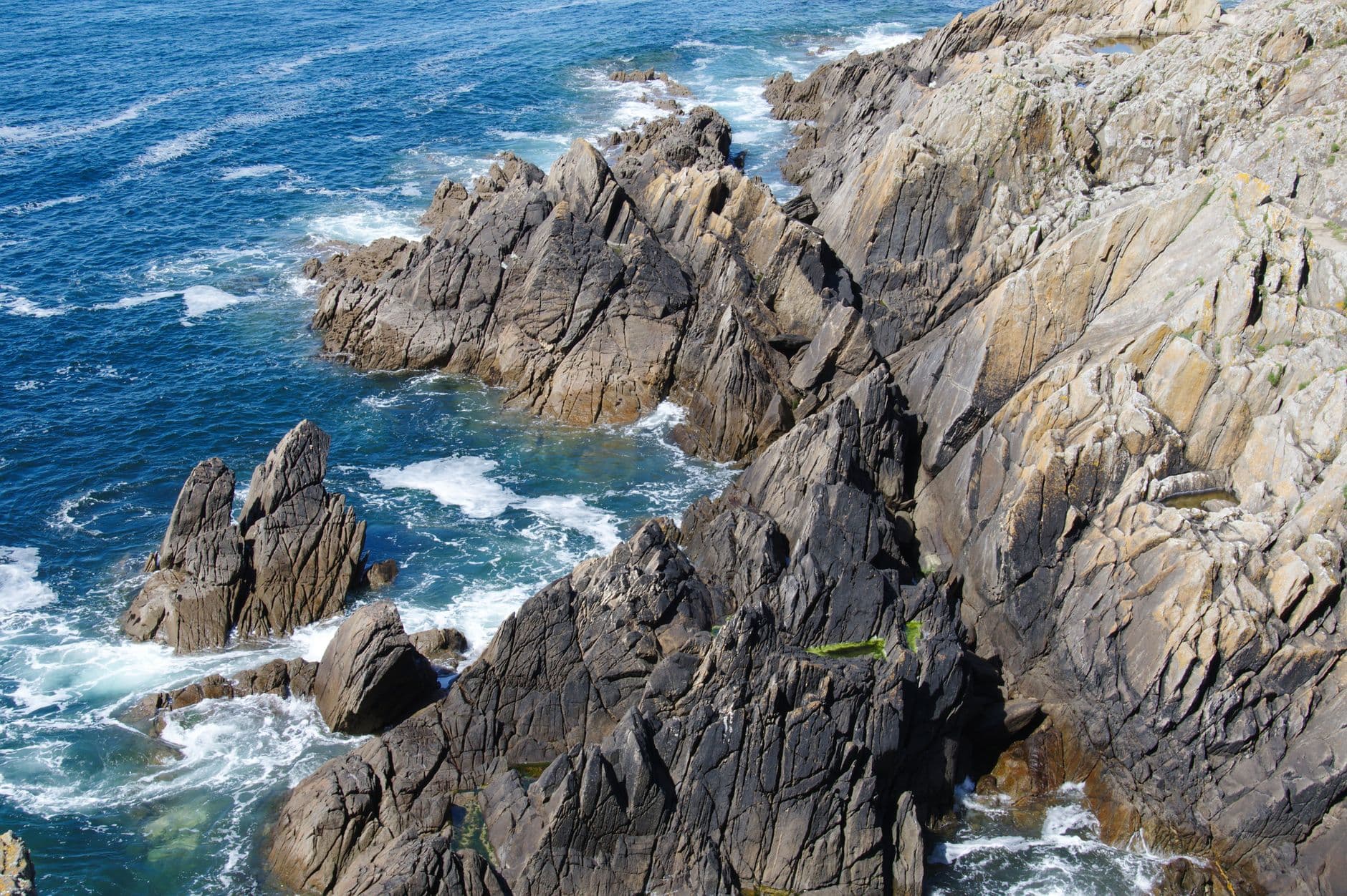 Beautiful rocky coastline in Le Conquet, Brittany, France with crashing waves and dramatic cliffs.