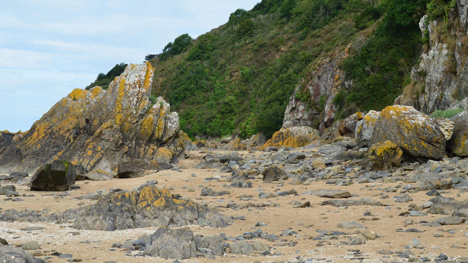 Scenic view of rocky cliffs and sandy beach in Saint-Jean-le-Thomas, Normandie, France.