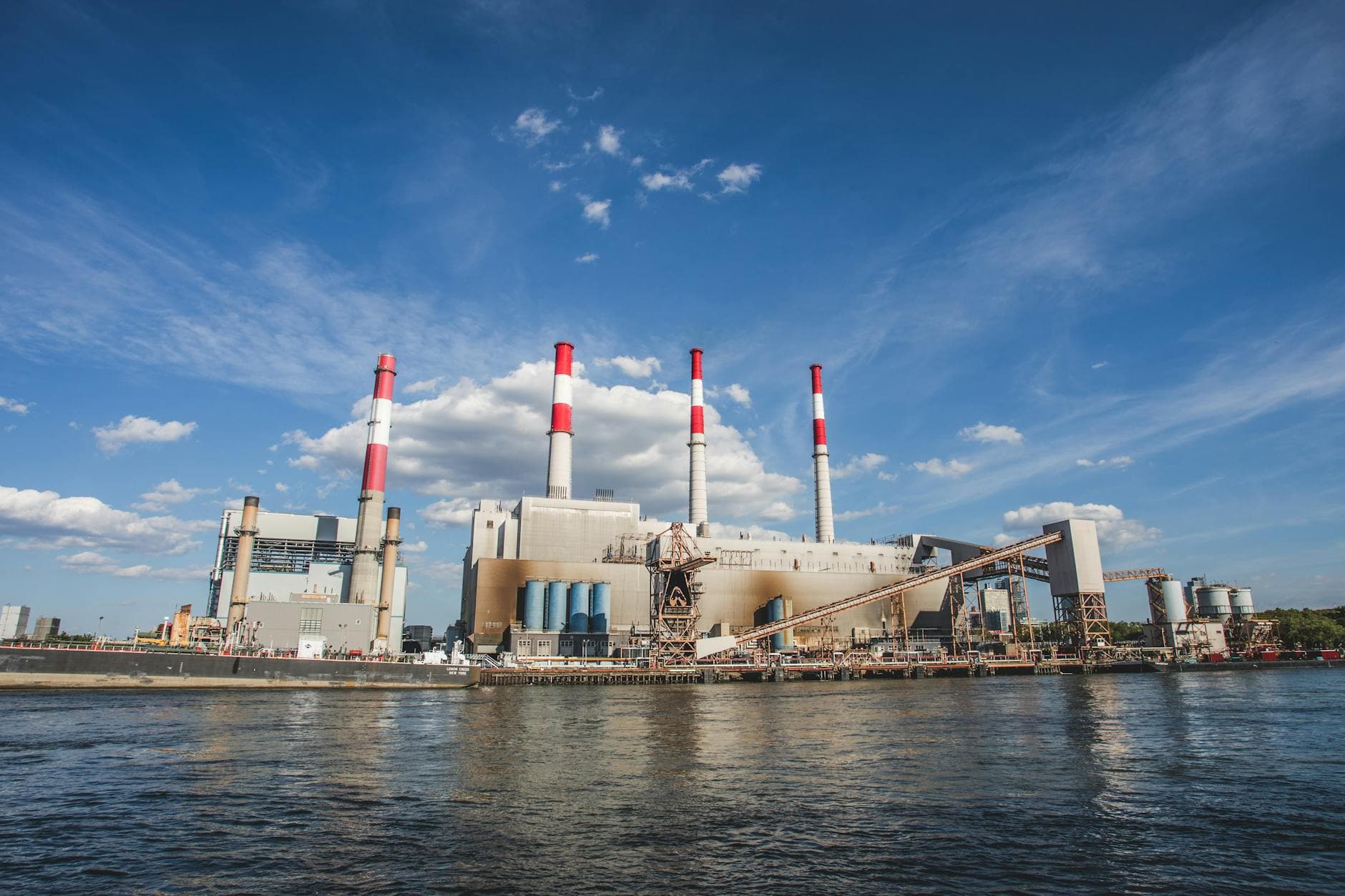 A wide view of Ravenswood Generating Station with chimneys and waterfront in New York City.