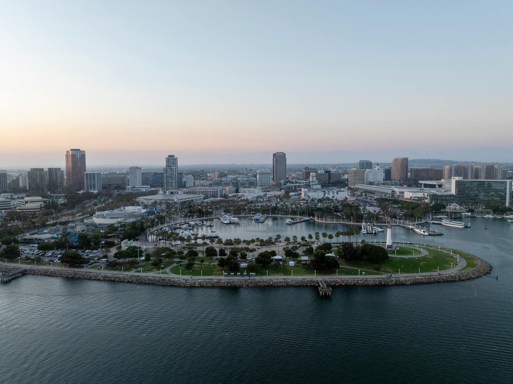 Stunning aerial view of Long Beach, CA skyline with harbor at dusk.