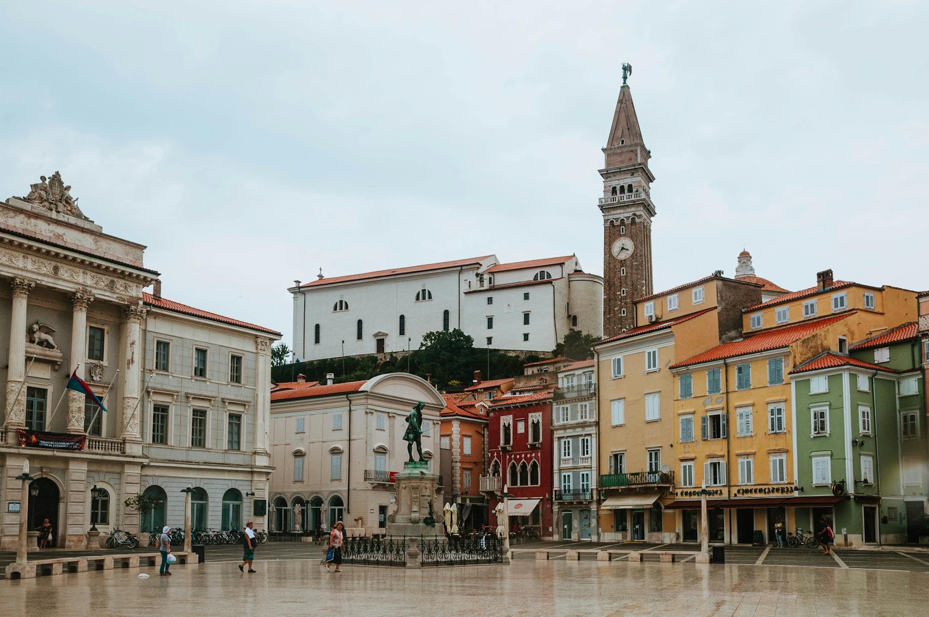 Picturesque view of a historic square in Piran, Slovenia featuring colorful buildings and a clock tower.