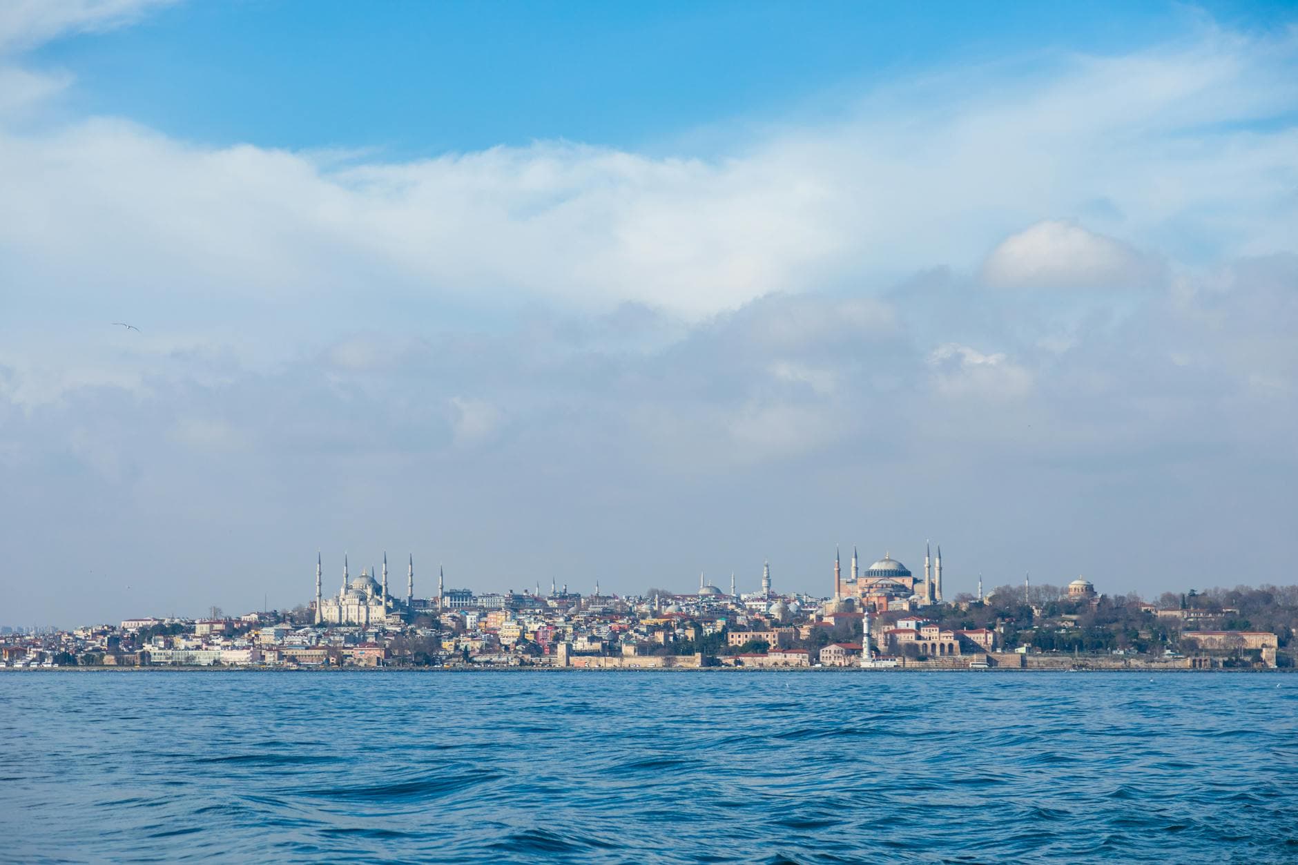Scenic view of Istanbul's skyline featuring historic mosques and the Bosphorus under a bright blue sky.