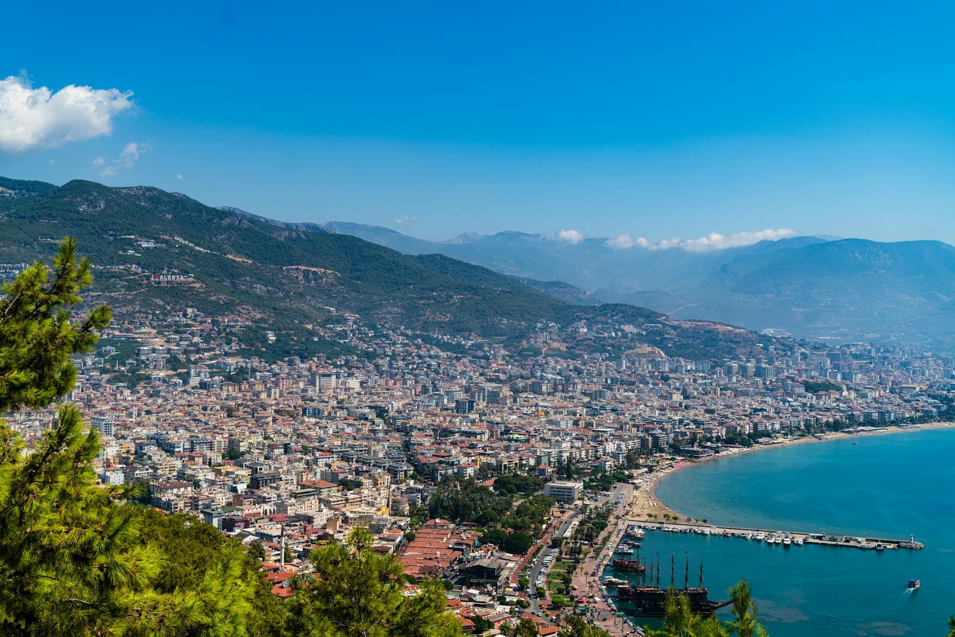 Stunning aerial view of Alanya's coastal cityscape, highlighting mountains and the Mediterranean.