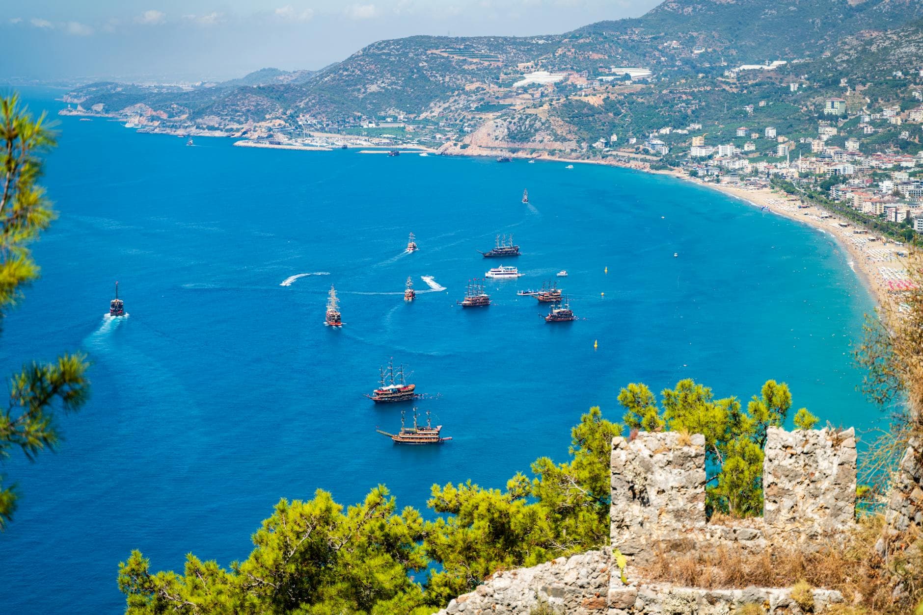 Breathtaking aerial view of ships near Alanya, Türkiye, with Kizil Kule and the castle in view.