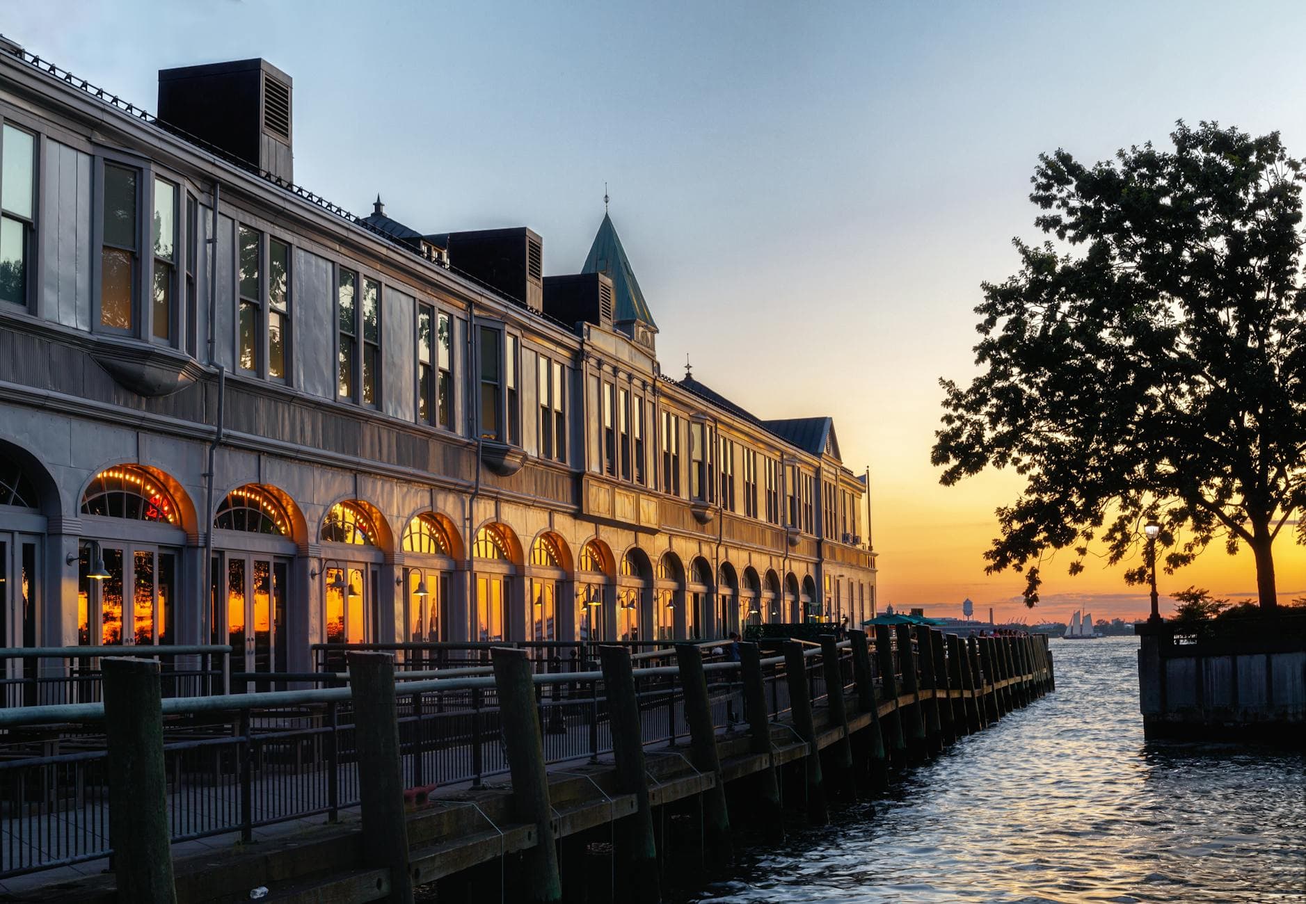 Dramatic sunset view of Manhattan Beach Pier with elegant architecture reflecting on the water.