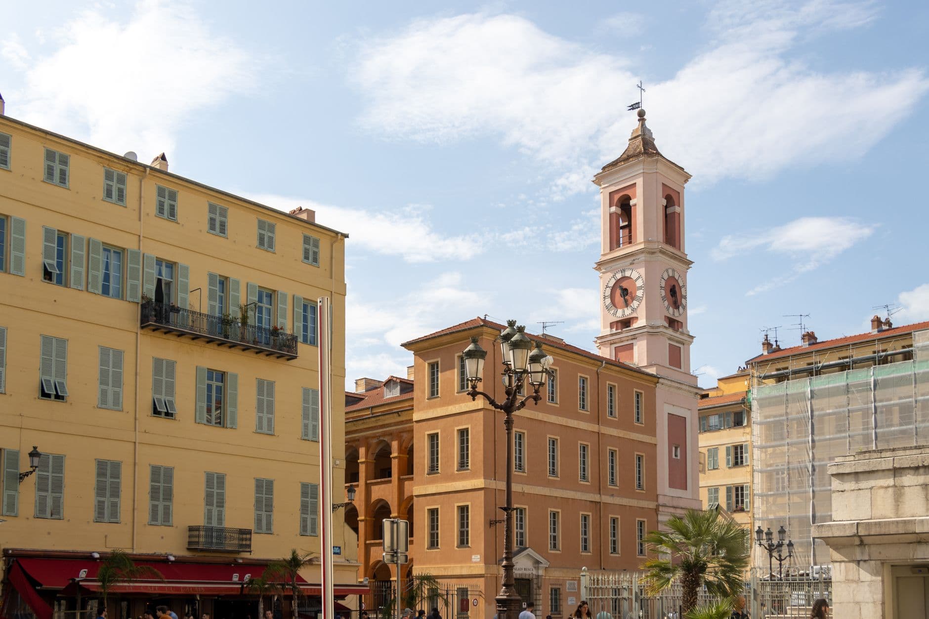 Charming architectural view of Palais Rusca with a historic clock tower in Nice, France.