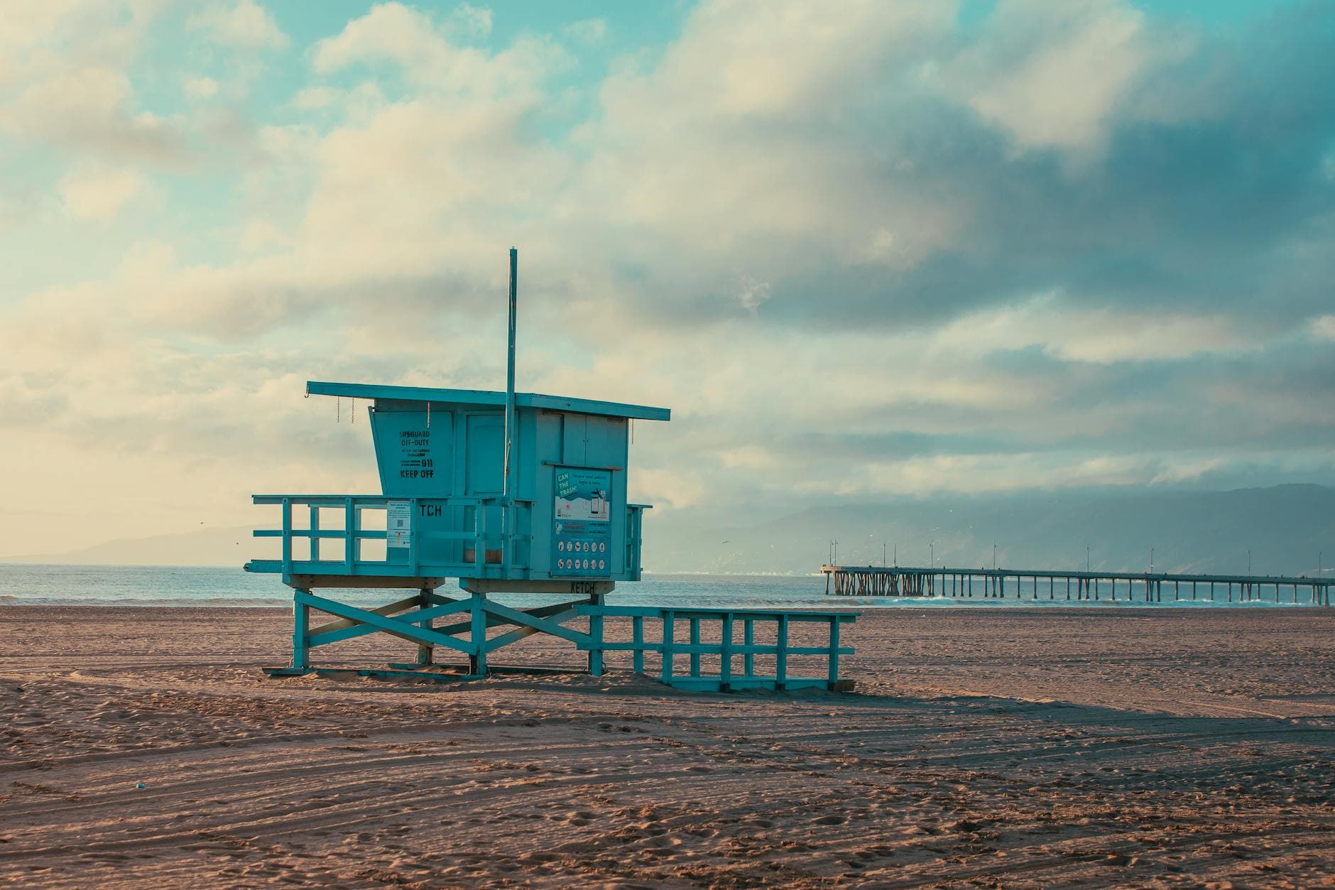Tranquil sunrise at Marina del Rey beach showcasing a classic lifeguard tower and serene ocean views.