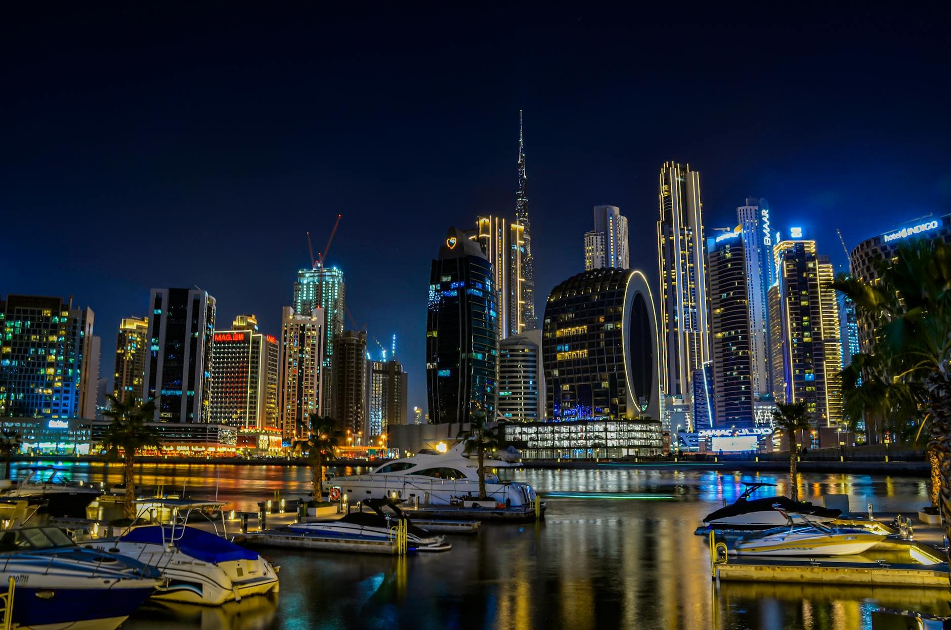 A breathtaking view of Dubai Marina's illuminated skyline at night, reflecting on the tranquil water.
