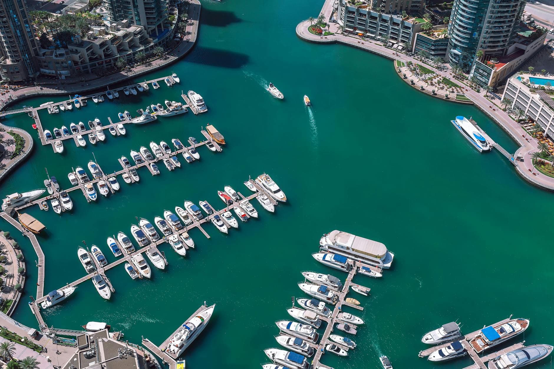 Captivating aerial shot of Dubai Marina showcasing multiple yachts and bustling waterfront activity.