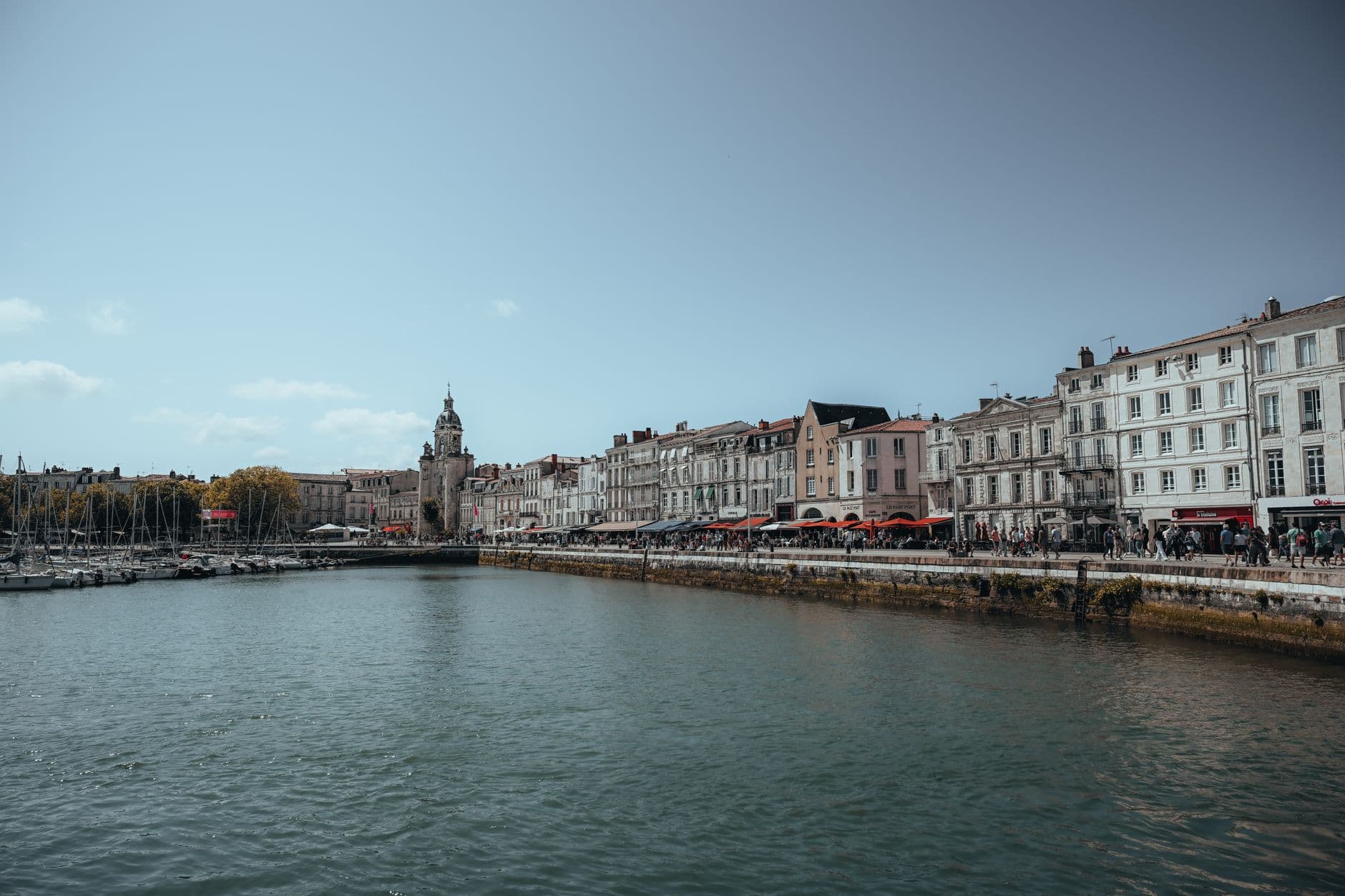 Scenic view of La Rochelle's waterfront with historic buildings by the sea under a clear sky.