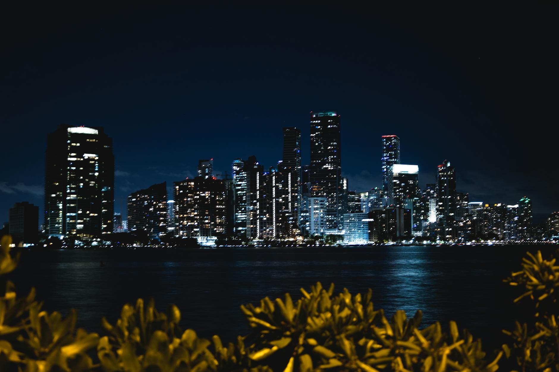 Captivating night view of Miami's skyline with shimmering city lights reflecting on the water.