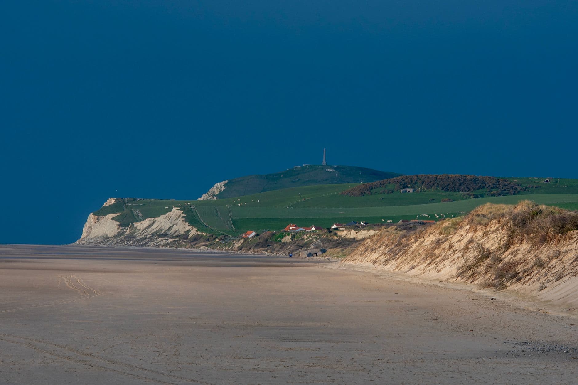 Captivating view of Escalles beach with cliffs and countryside landscape under a clear sky.
