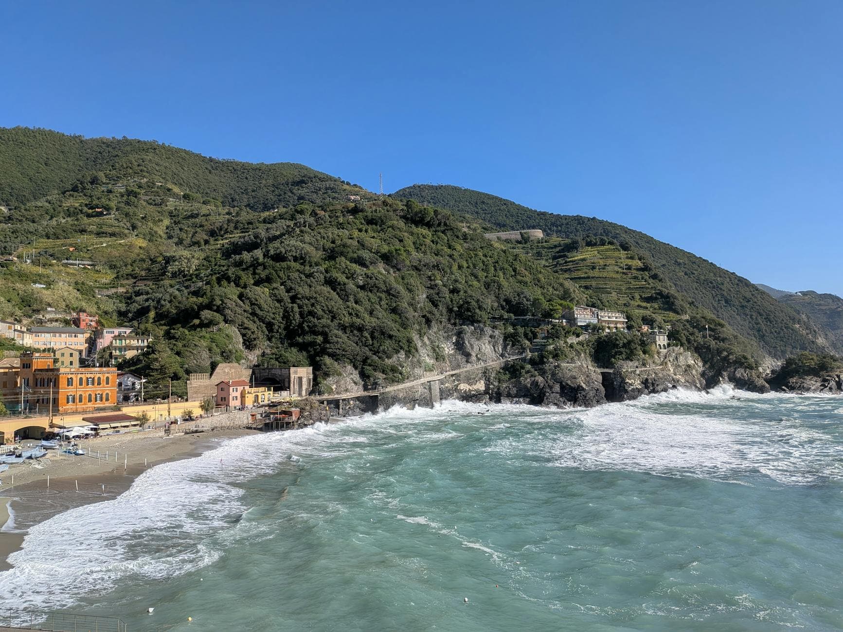 Captivating seascape of Monterosso Al Mare with lush hills and turquoise waves.