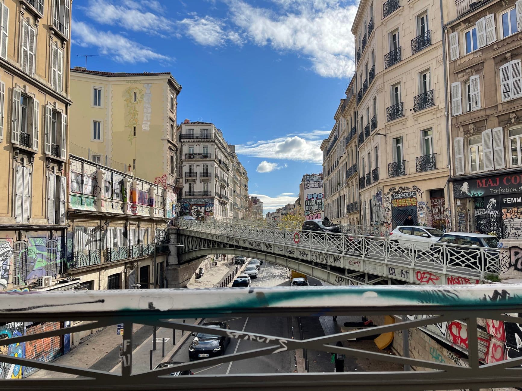View of a graffiti-covered street and bridge in the bustling city of Marseille, France.