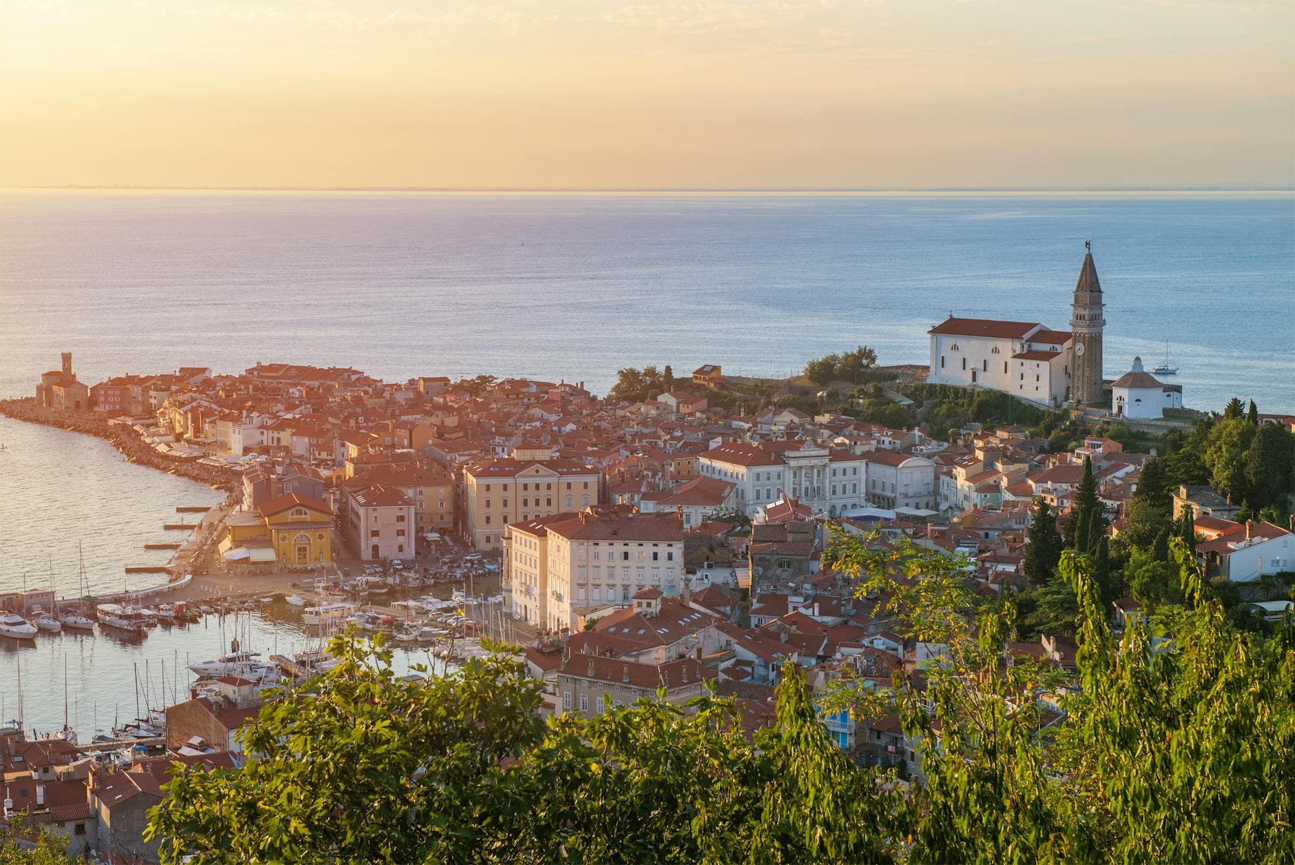 Scenic aerial view of a seaside town with historic architecture at sunset.