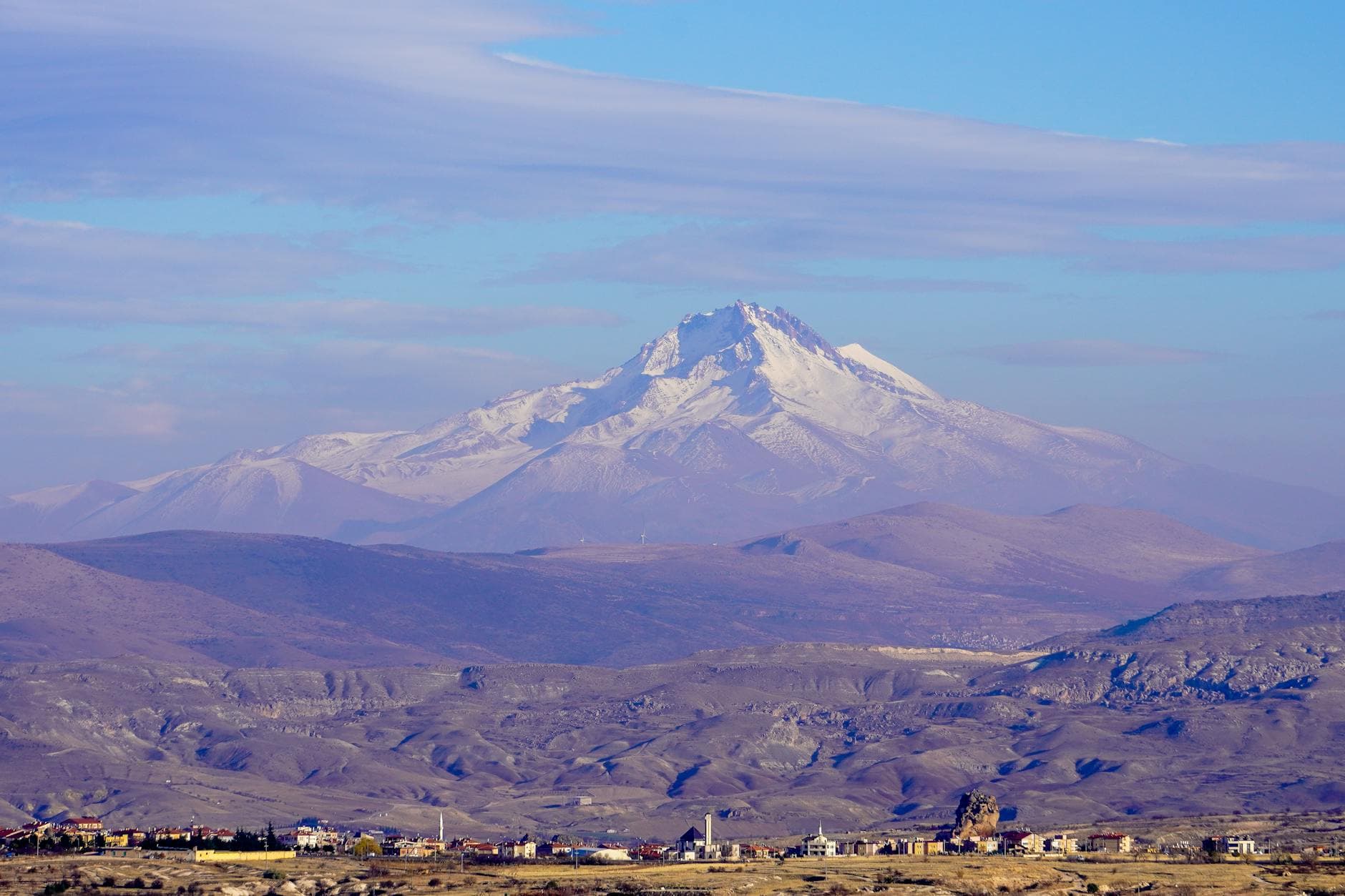 Breathtaking view of Mount Erciyes with a small town in the foreground, taken in Uçhisar, Nevşehir.