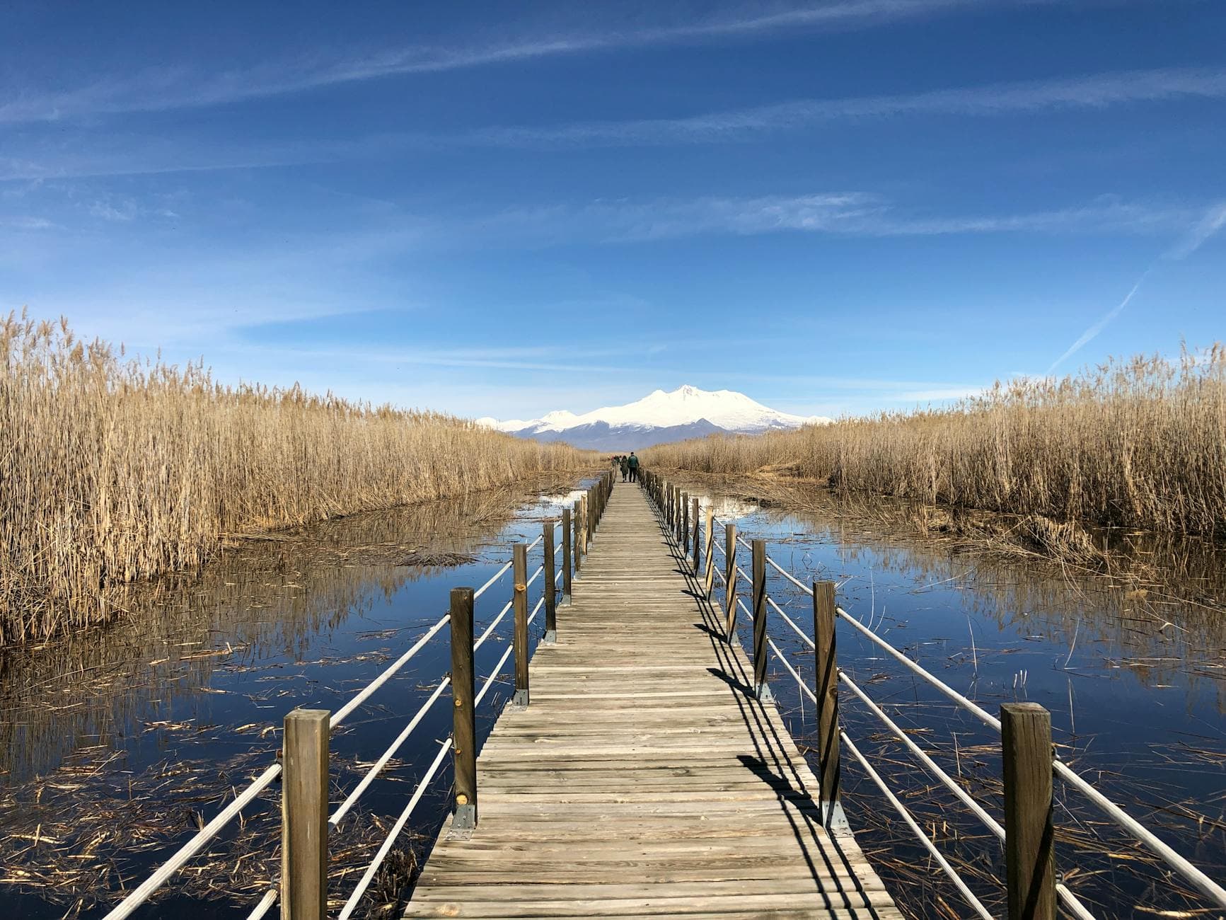 Scenic view of a wooden walkway in Kayseri, Türkiye, with Mount Erciyes in the background.