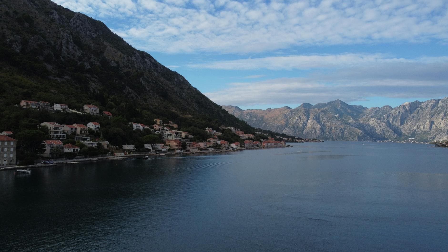 A scenic view of the coastal town Muo in Montenegro, featuring mountains and serene waters.