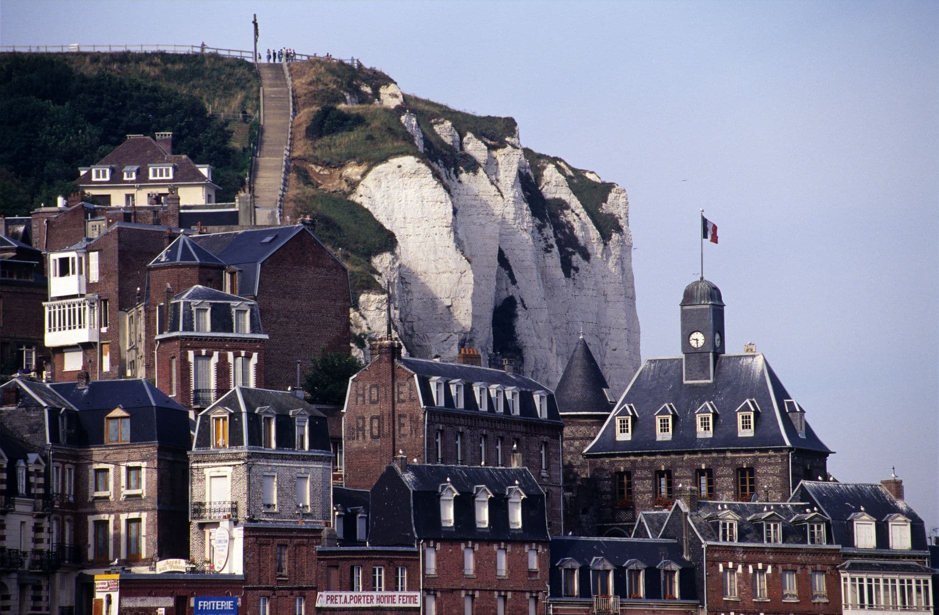 Charming coastal town of Le Tréport with historic architecture set against striking white cliffs.