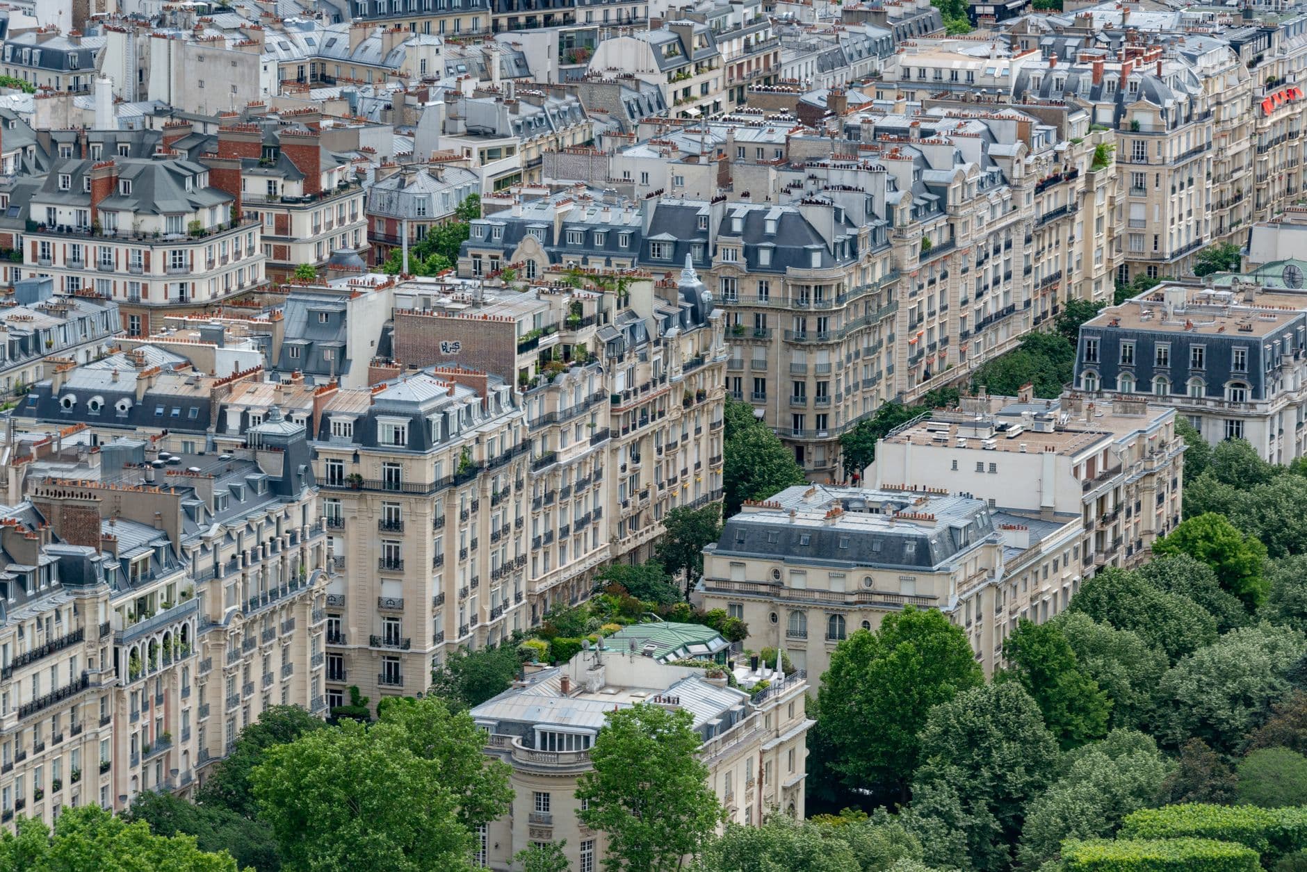 Aerial cityscape capturing traditional Parisian architecture and greenery.