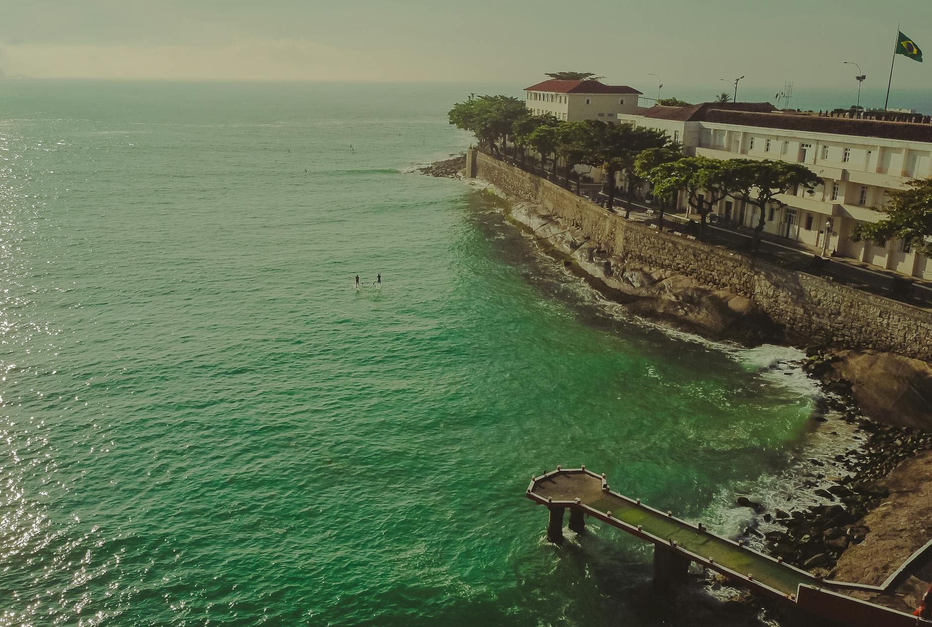 Stunning aerial view of Rio de Janeiro's coastline with calm emerald waters and historic buildings.