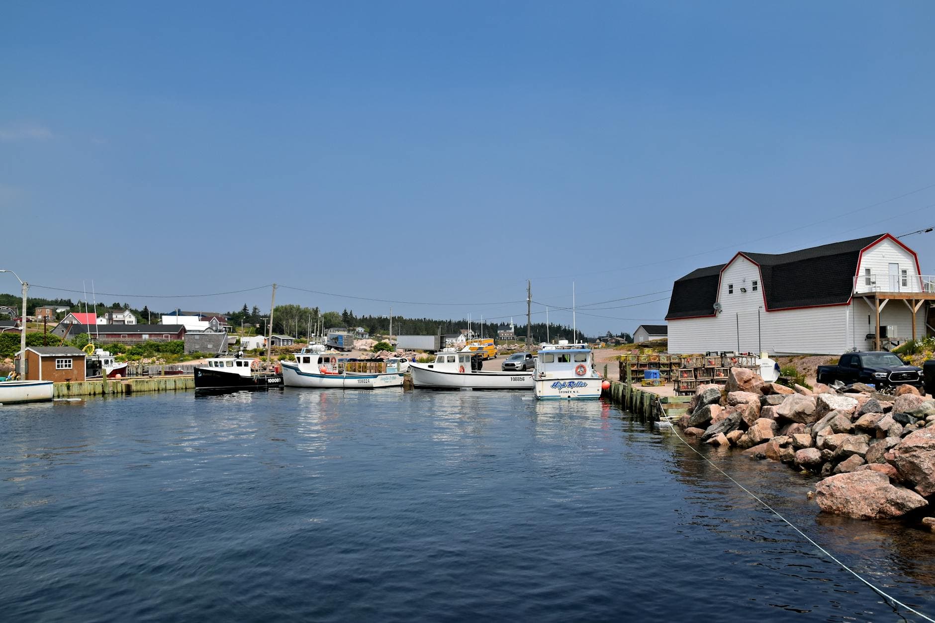 Peaceful harbor with fishing boats and coastal village scenery in Nova Scotia, Canada.
