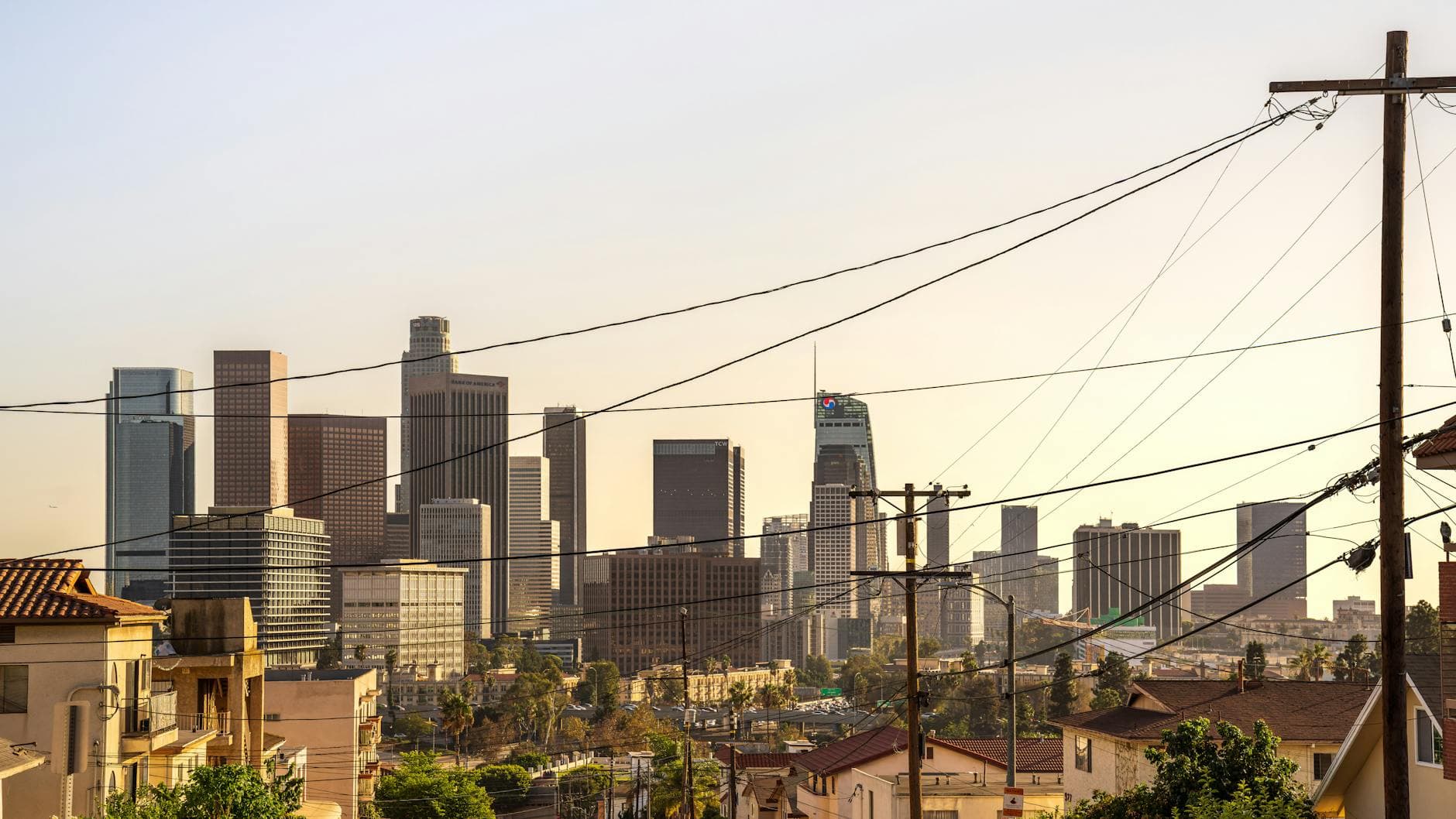 Capture of downtown Los Angeles skyline under a warm sunset, showcasing iconic skyscrapers and urban landscape.