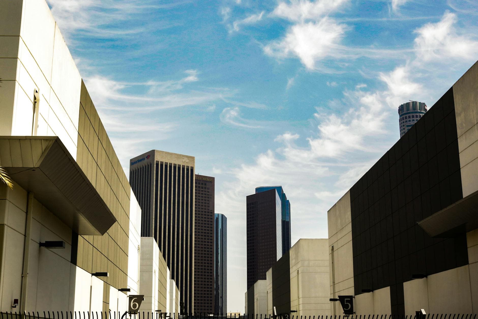 Skyline of downtown Los Angeles with modern skyscrapers against a blue sky.