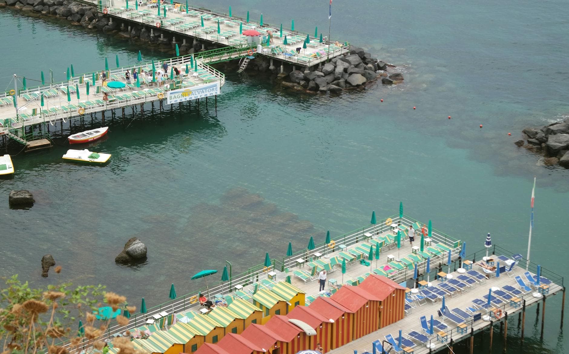 A colorful beach resort with vibrant umbrellas and decking in Sorrento, Italy.