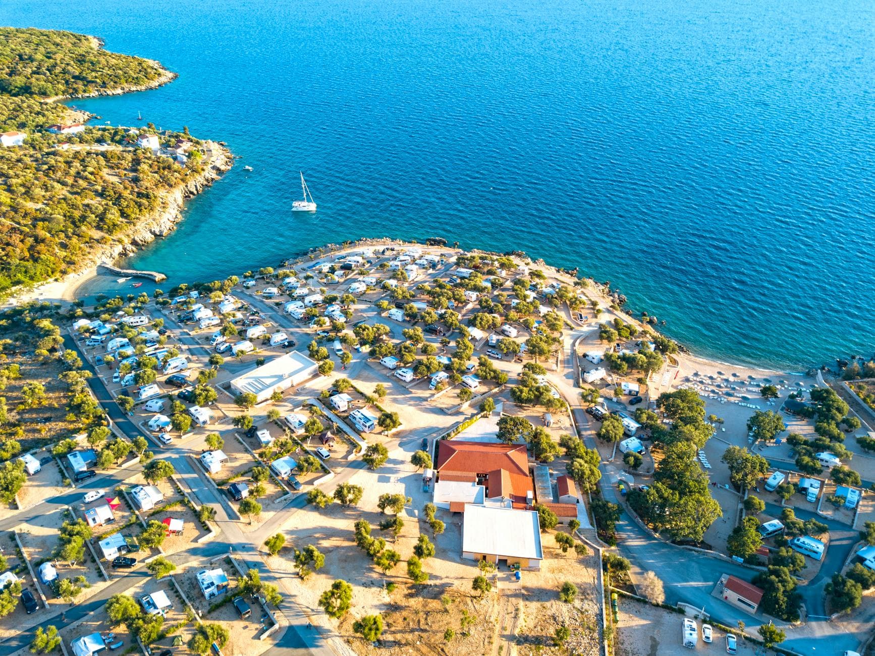 Aerial view of sunny campgrounds and coastline in Novalja, Croatia.