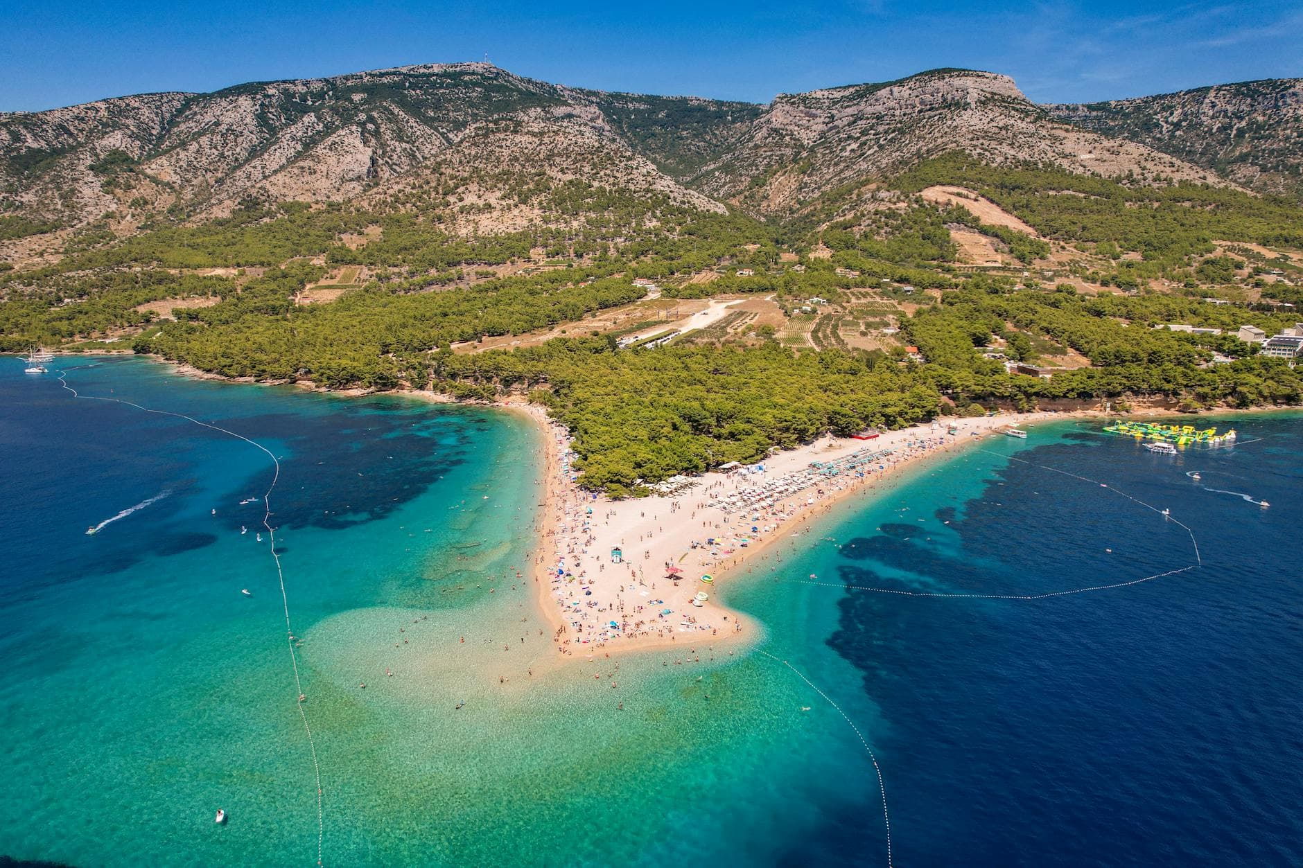 Stunning aerial view of Zlatni Rat Beach with turquoise waters and lush surroundings.