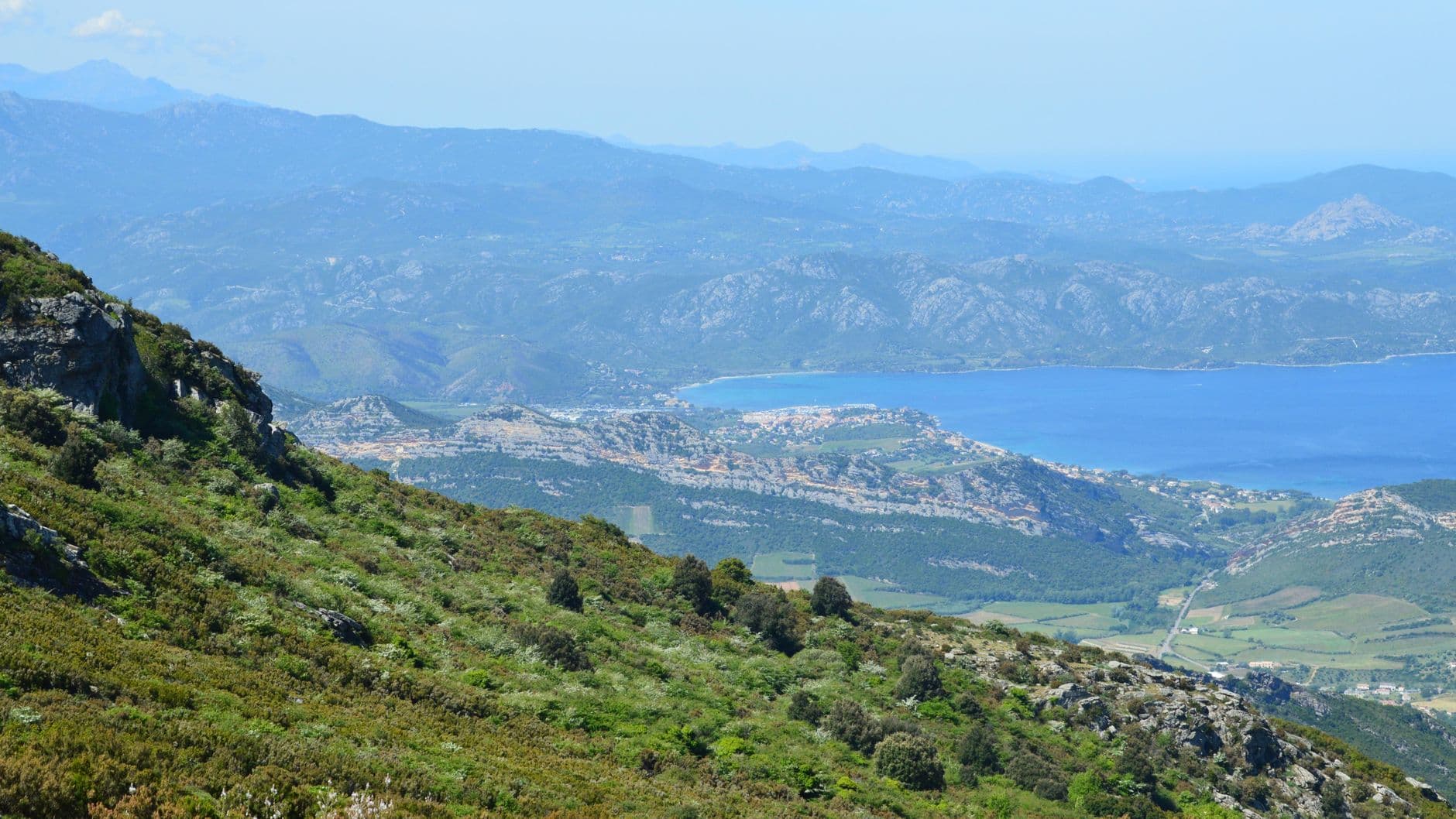 A breathtaking aerial view of Bastia's coastline and mountains in Corse, France, showcasing natural beauty.