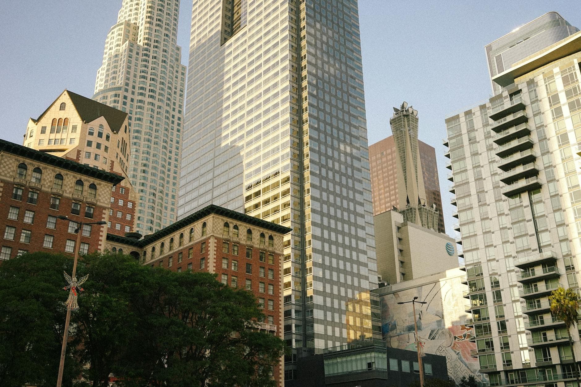A stunning view of modern skyscrapers contrasting with historic architecture in downtown at sunset.