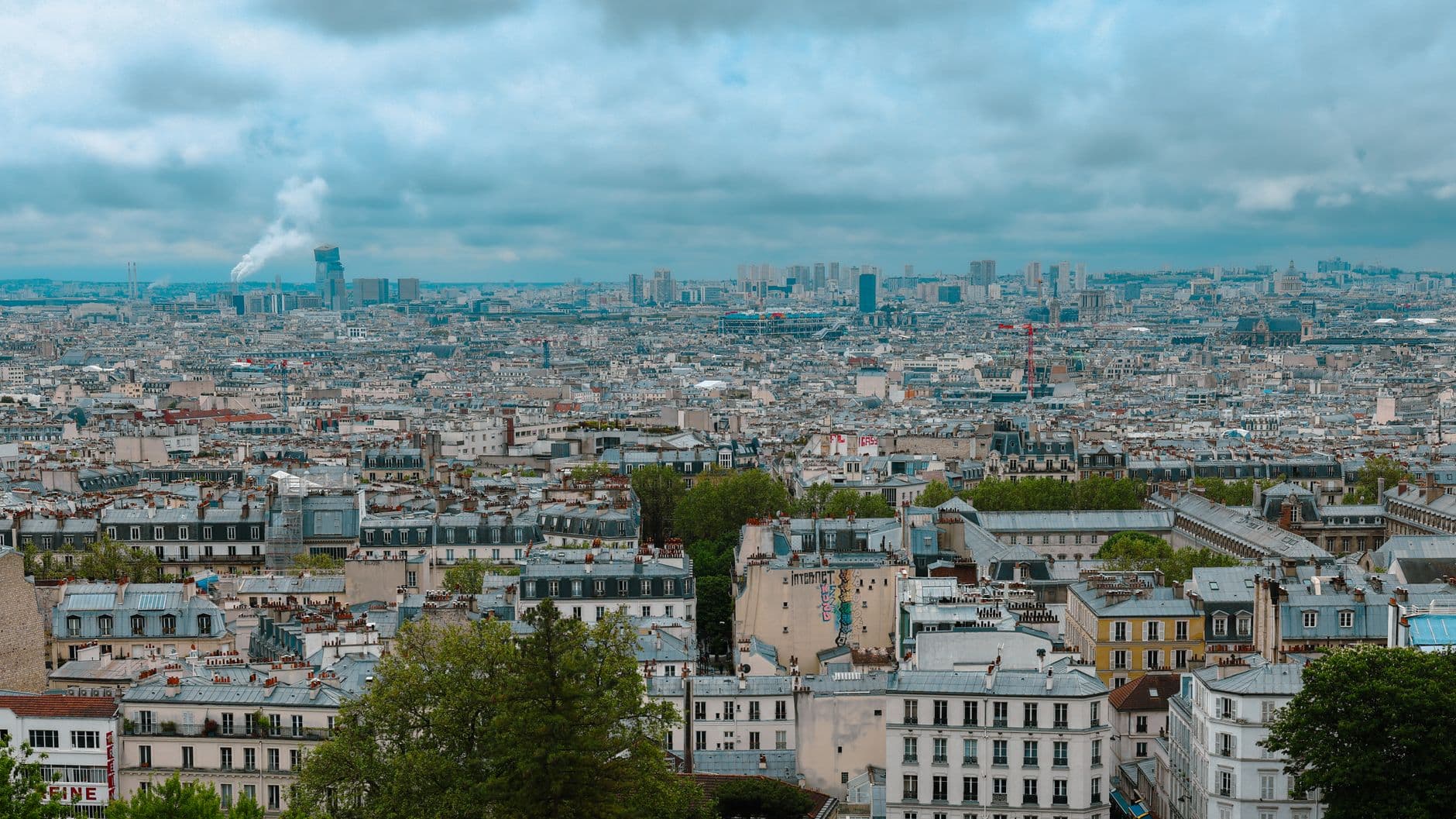 Stunning view of Paris skyline with historic rooftops on a cloudy day, seen from Montmartre.