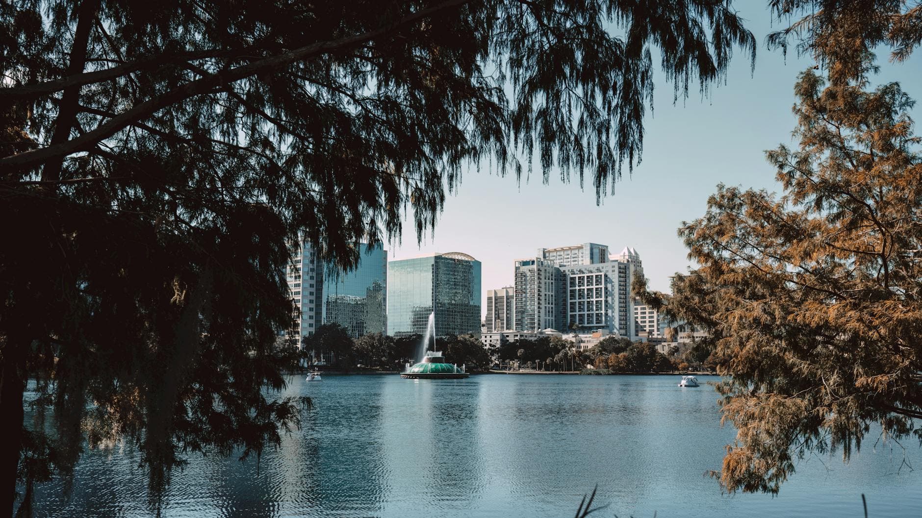 Captivating view of downtown Orlando skyline framed by trees at Lake Eola.