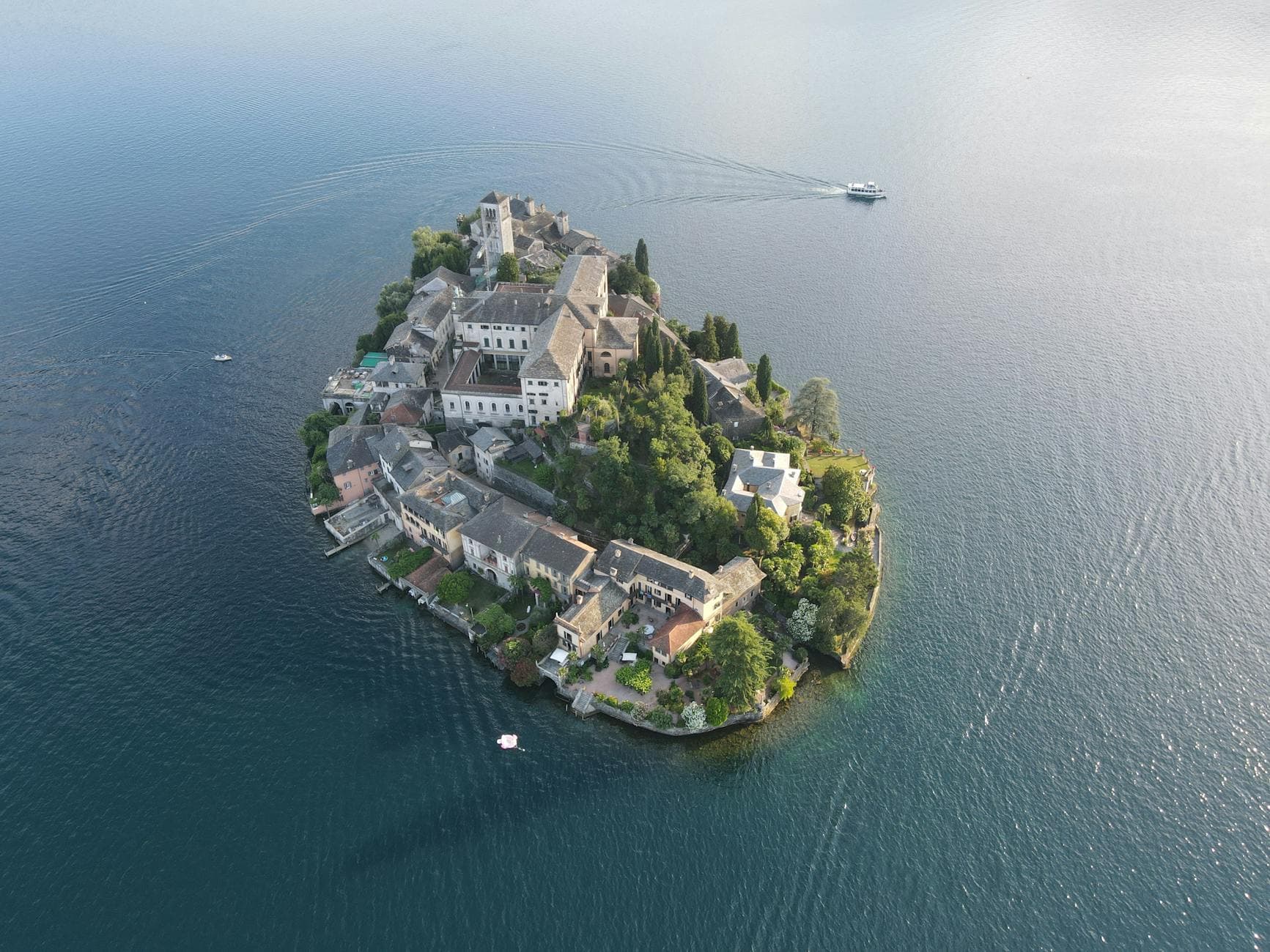 Stunning aerial shot of Isola San Giulio in Lake Orta, Italy, surrounded by peaceful water.