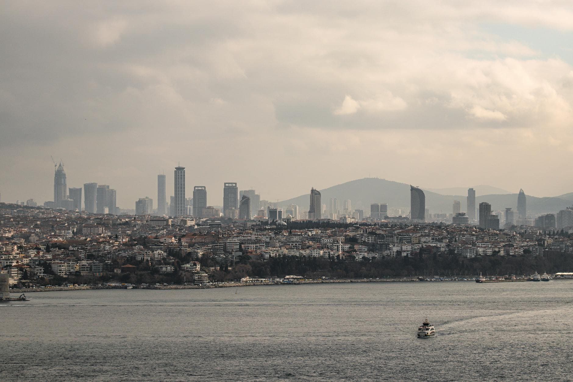 A stunning aerial view of Istanbul's skyline, capturing the Bosporus strait and urban sprawl under a dramatic sky.